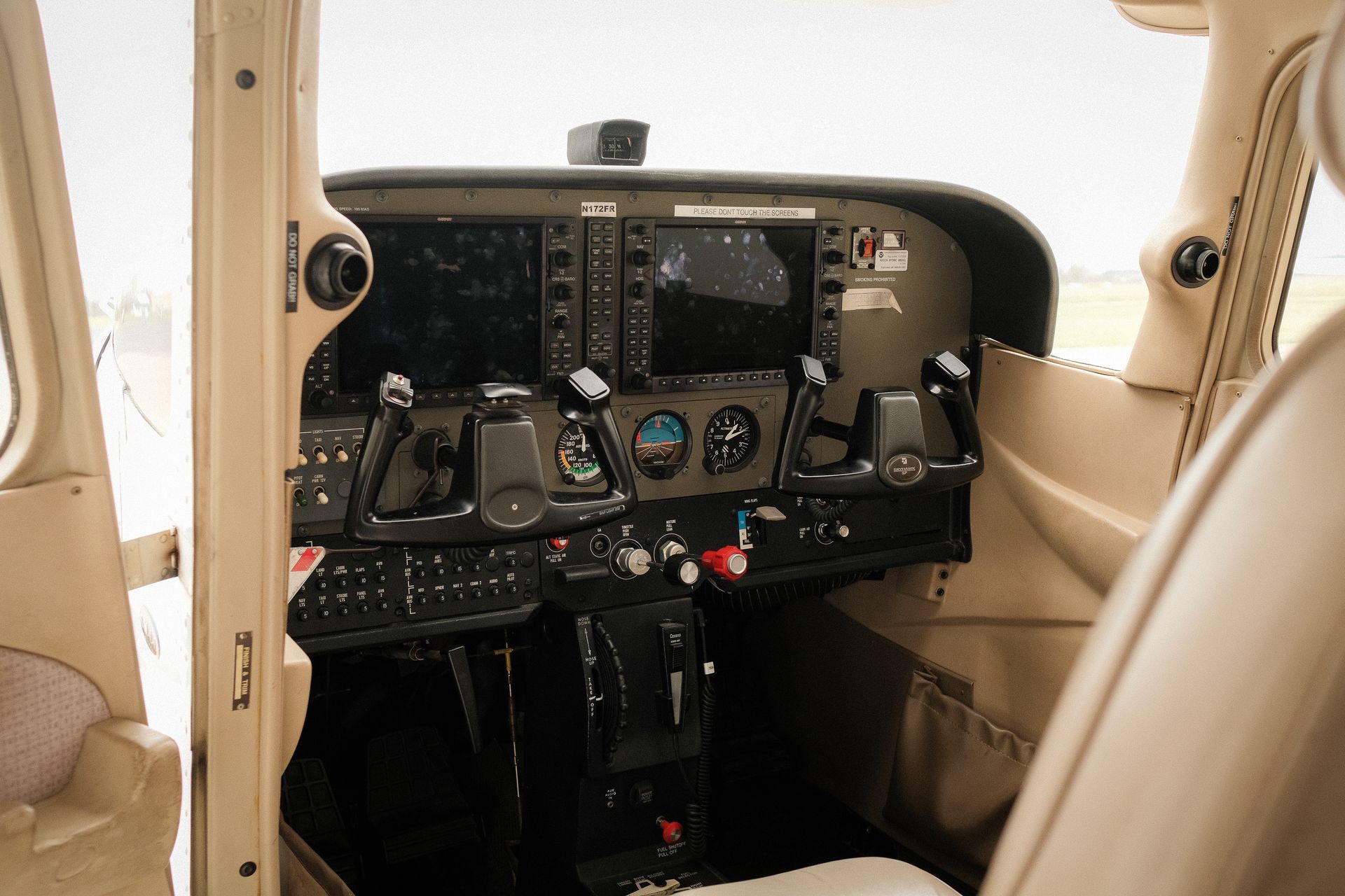 A cockpit of an airplane with a lot of monitors