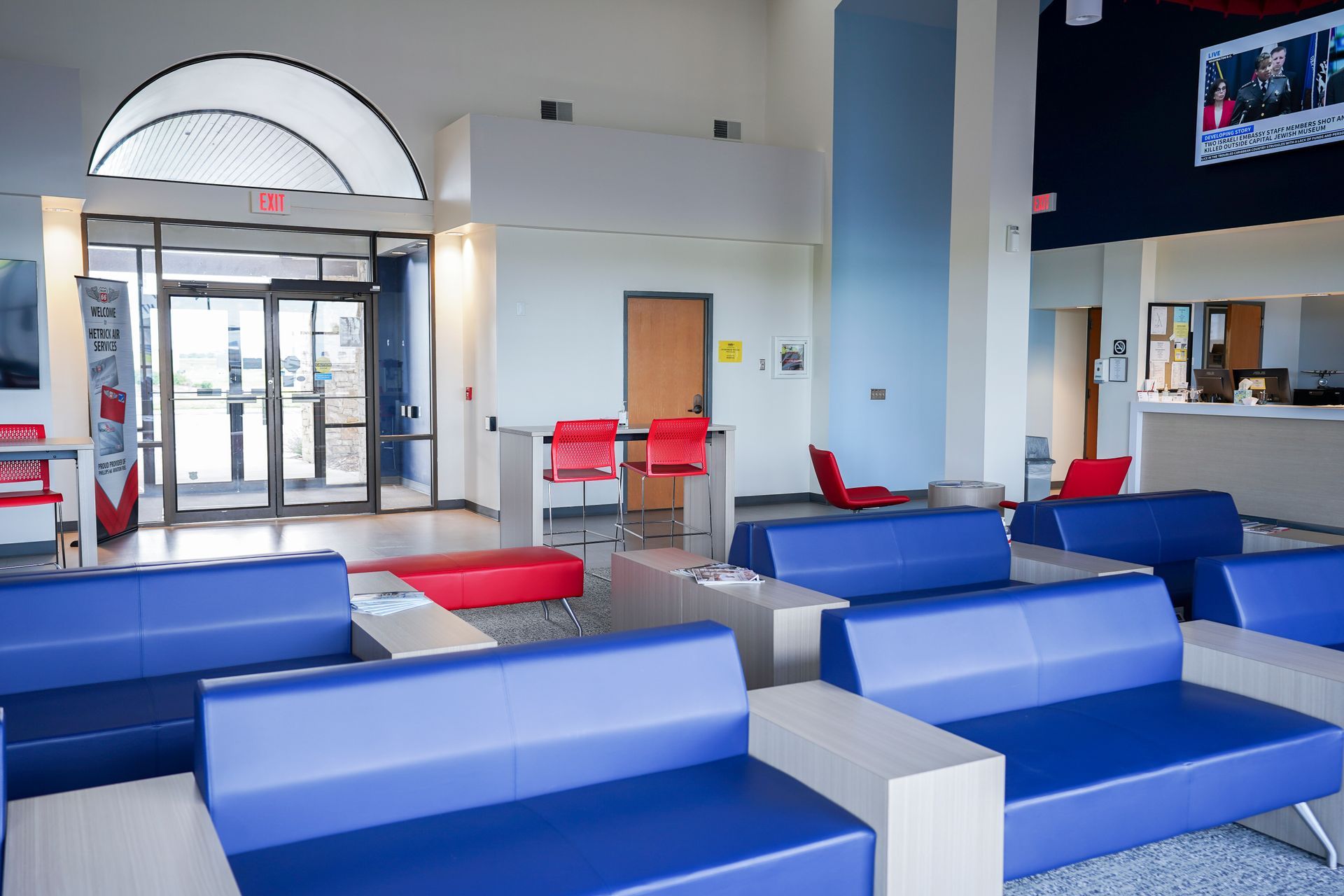 A waiting room with blue couches and red chairs