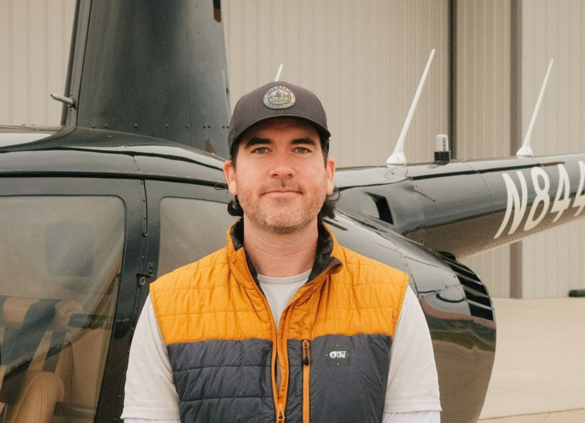 A man is standing in front of a small airplane.