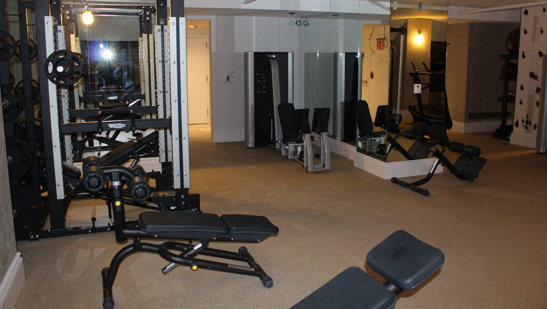 Hotel fitness center with benches and strength training machines at Lotte New York Palace