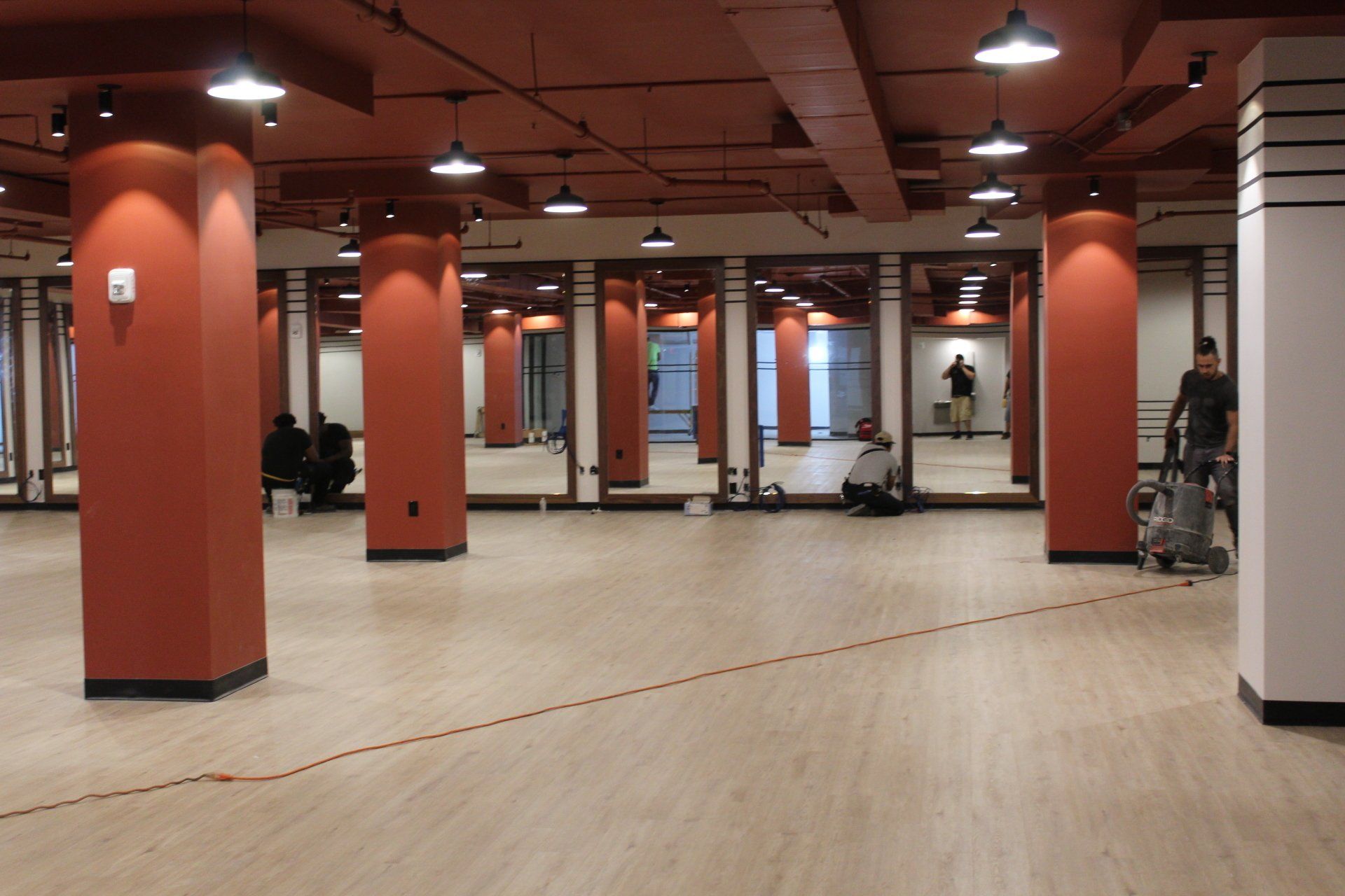 Spacious fitness room at Twenty Exchange Place with mirrors and hardwood flooring.