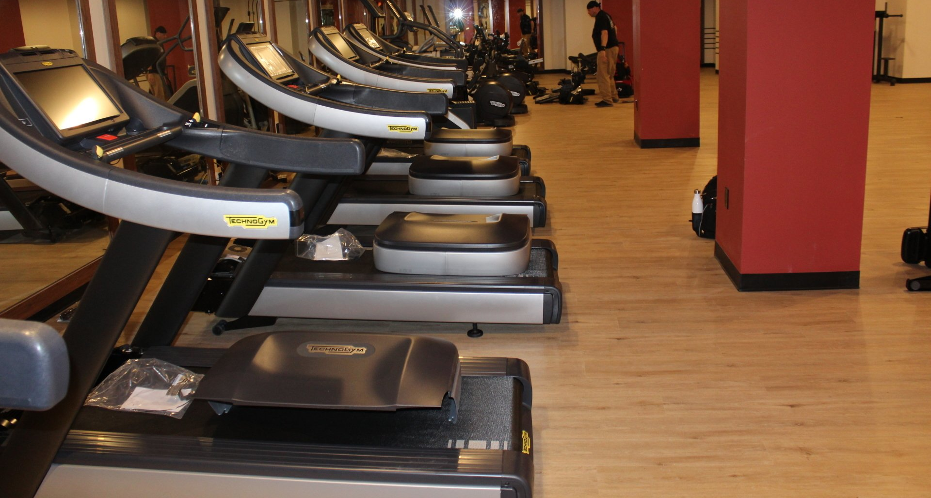 Fitness treadmills lined up in Twenty Exchange Place gym with wood flooring