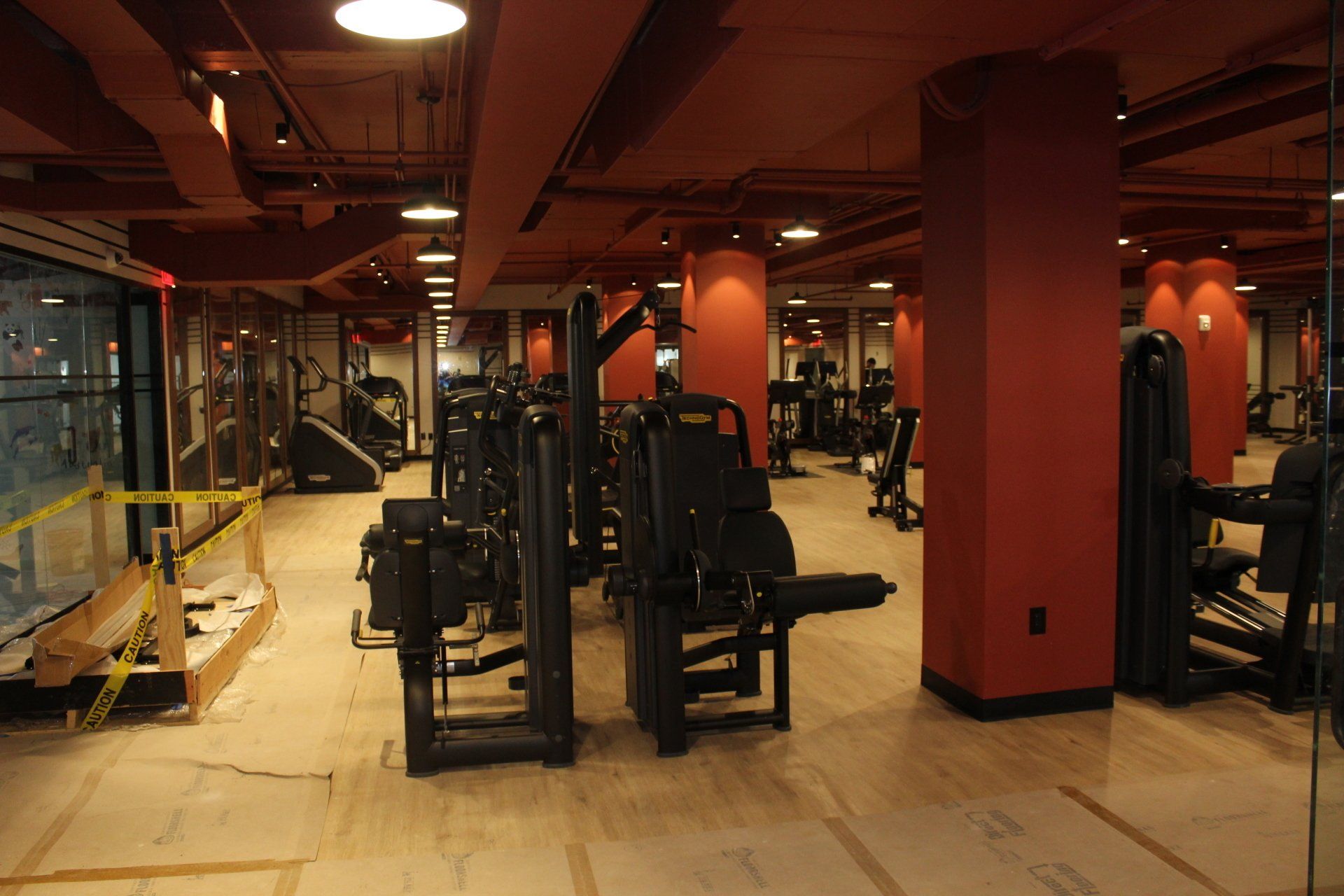 Weight training machines in Twenty Exchange Place gym under red ceiling