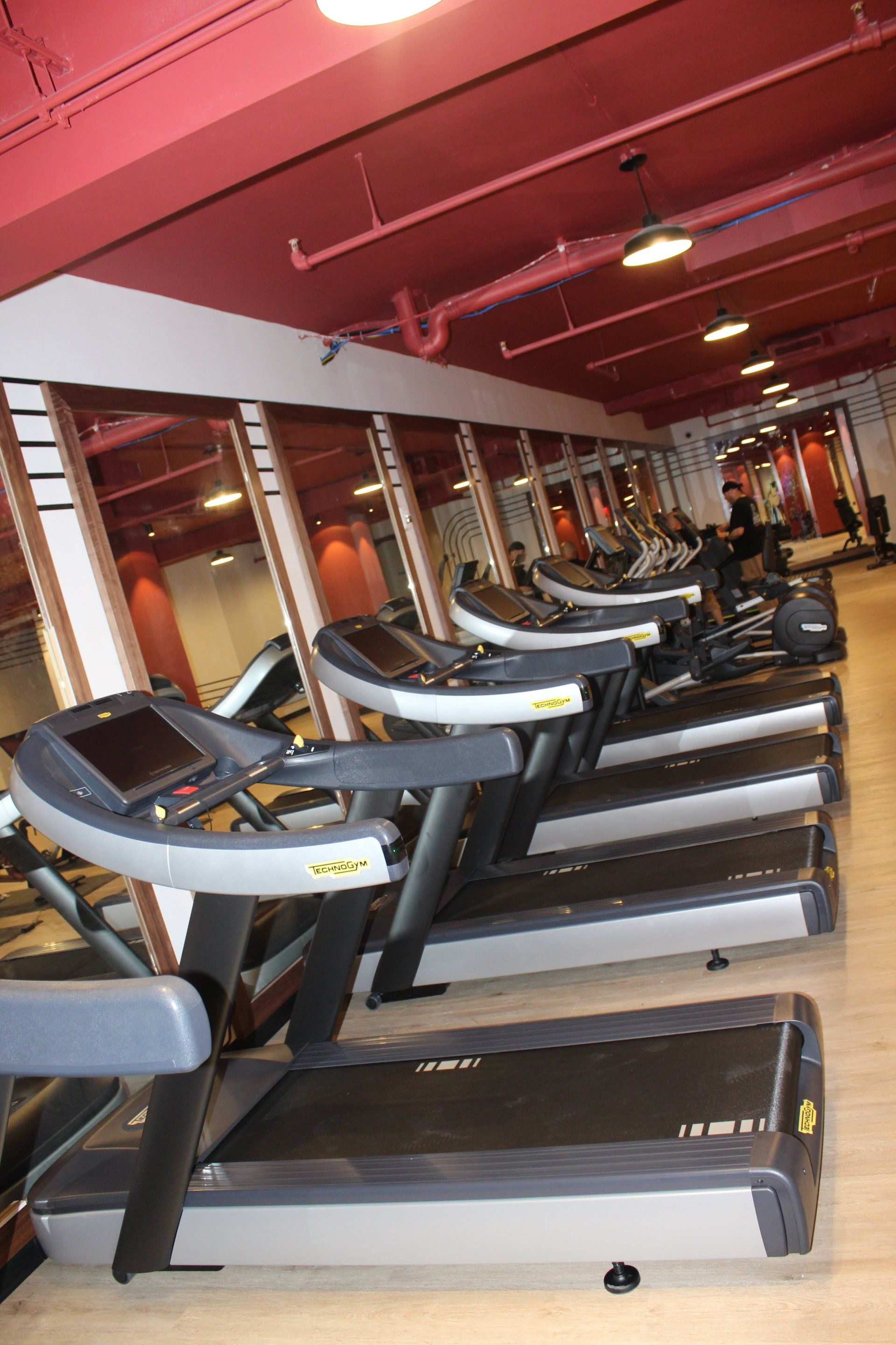 Row of treadmills inside Twenty Exchange Place gym with mirrors and bright lighting