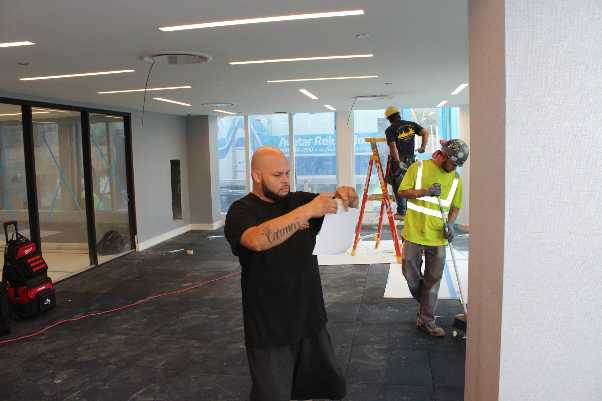 Workers measuring and completing interior finishing work inside Quay Tower renovation project.