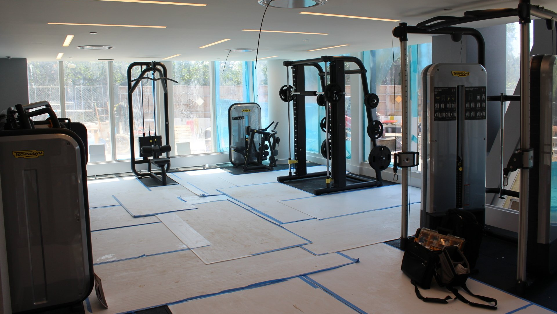 Quay Tower fitness center under setup with strength machines and natural light.