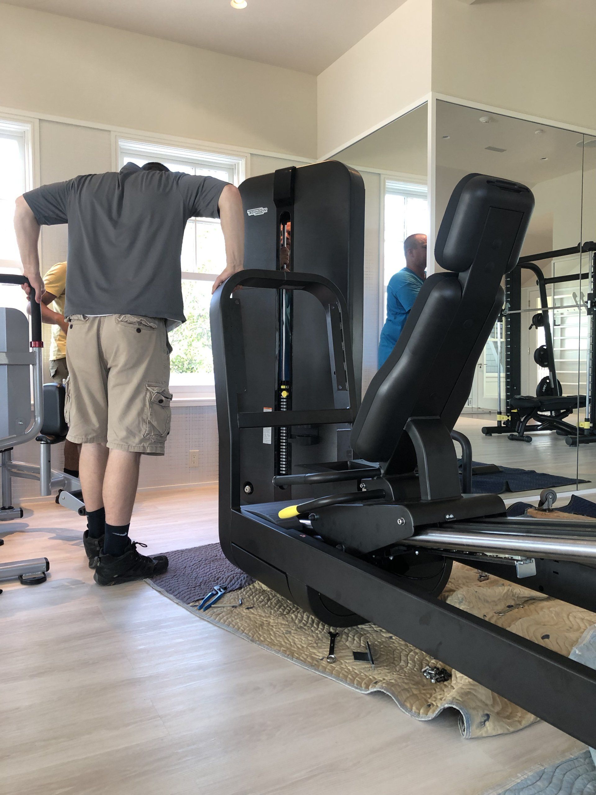 Gym equipment being installed inside residential home fitness room in Bridgehampton.