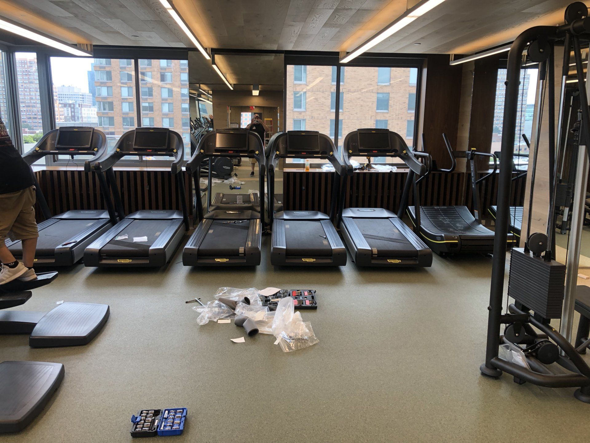 Row of treadmills and cardio machines lined up inside Iron State gym.