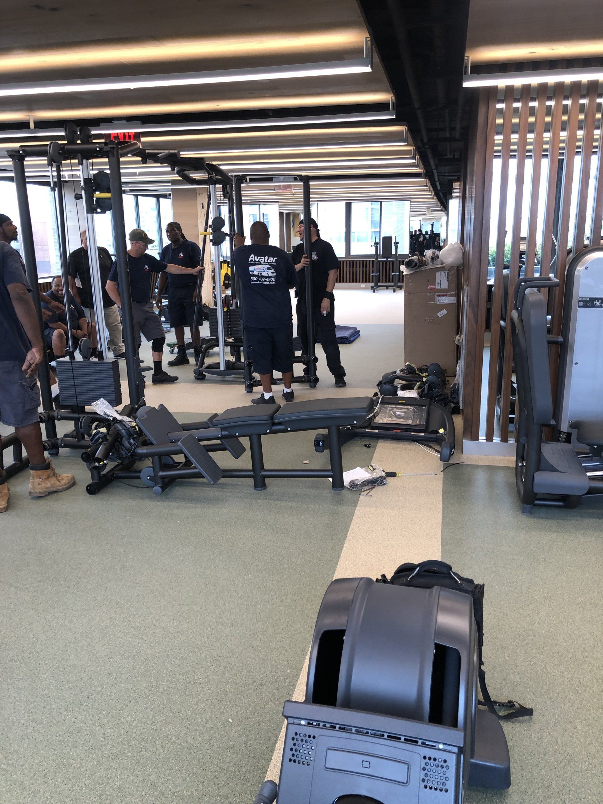 Gym installation team setting up new equipment at Iron State fitness center.