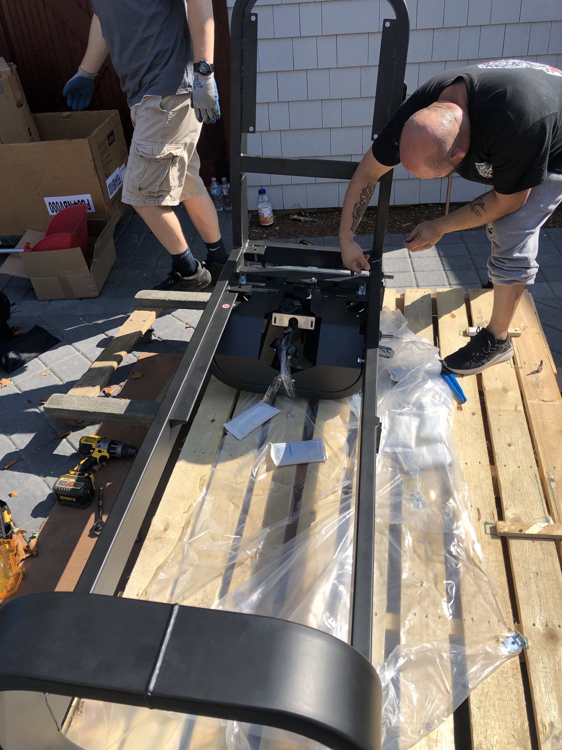 Workers installing gym machine frame during Bridgehampton home gym project.