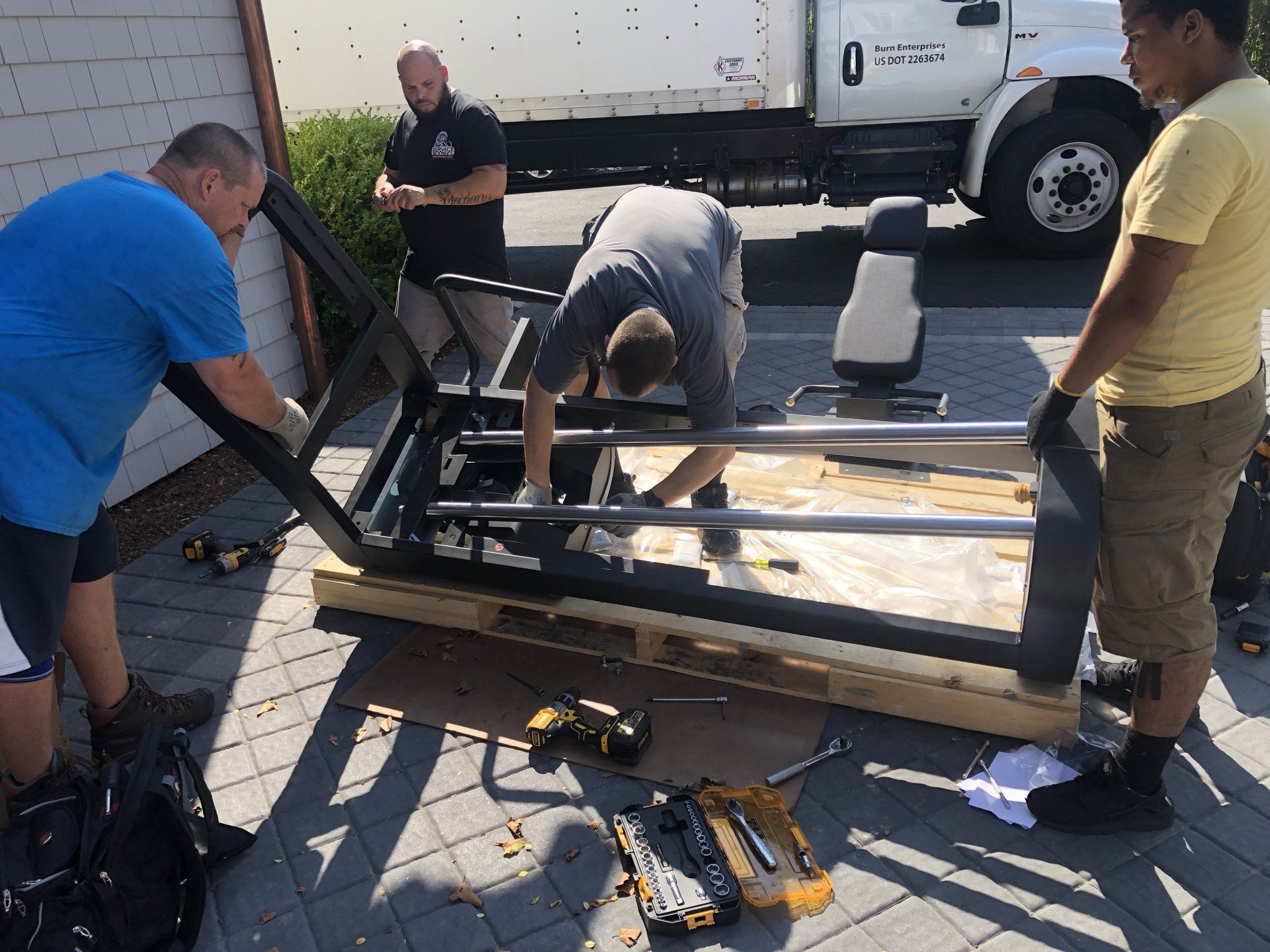 Team assembling fitness equipment outdoors at Bridgehampton residential project.