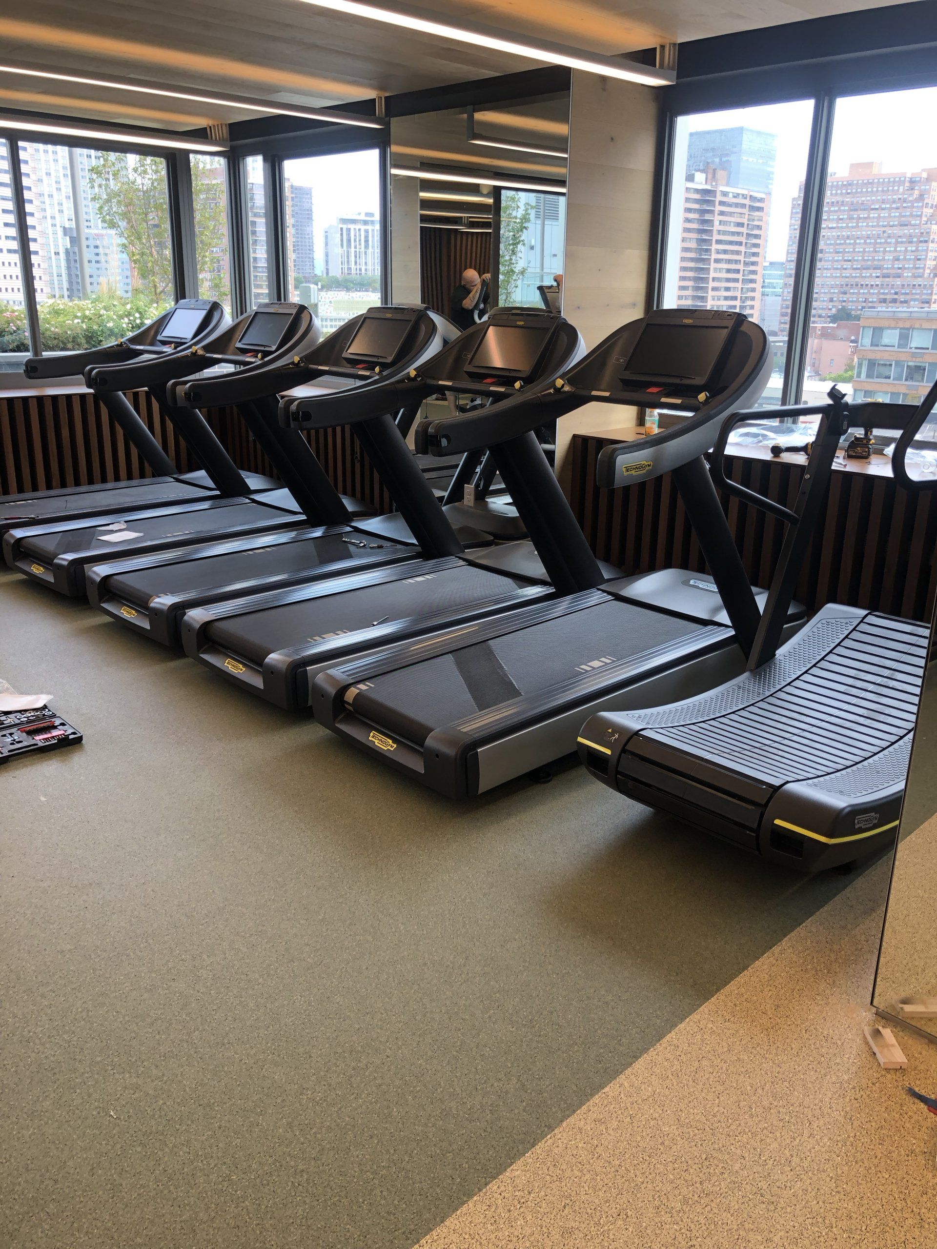 Row of treadmills in front of windows at Iron State fitness center.