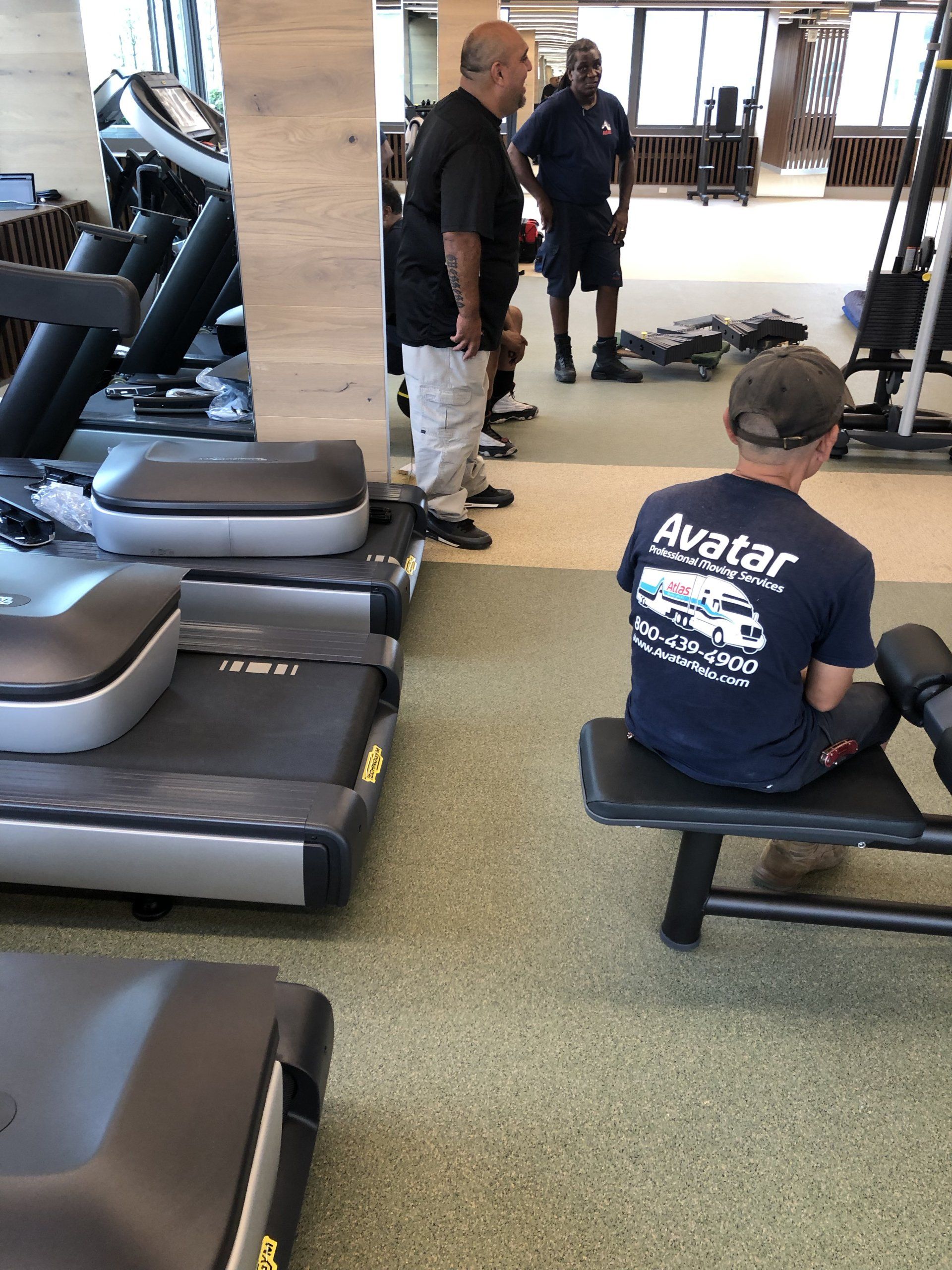 Technician setting up cardio equipment at Iron State fitness center.