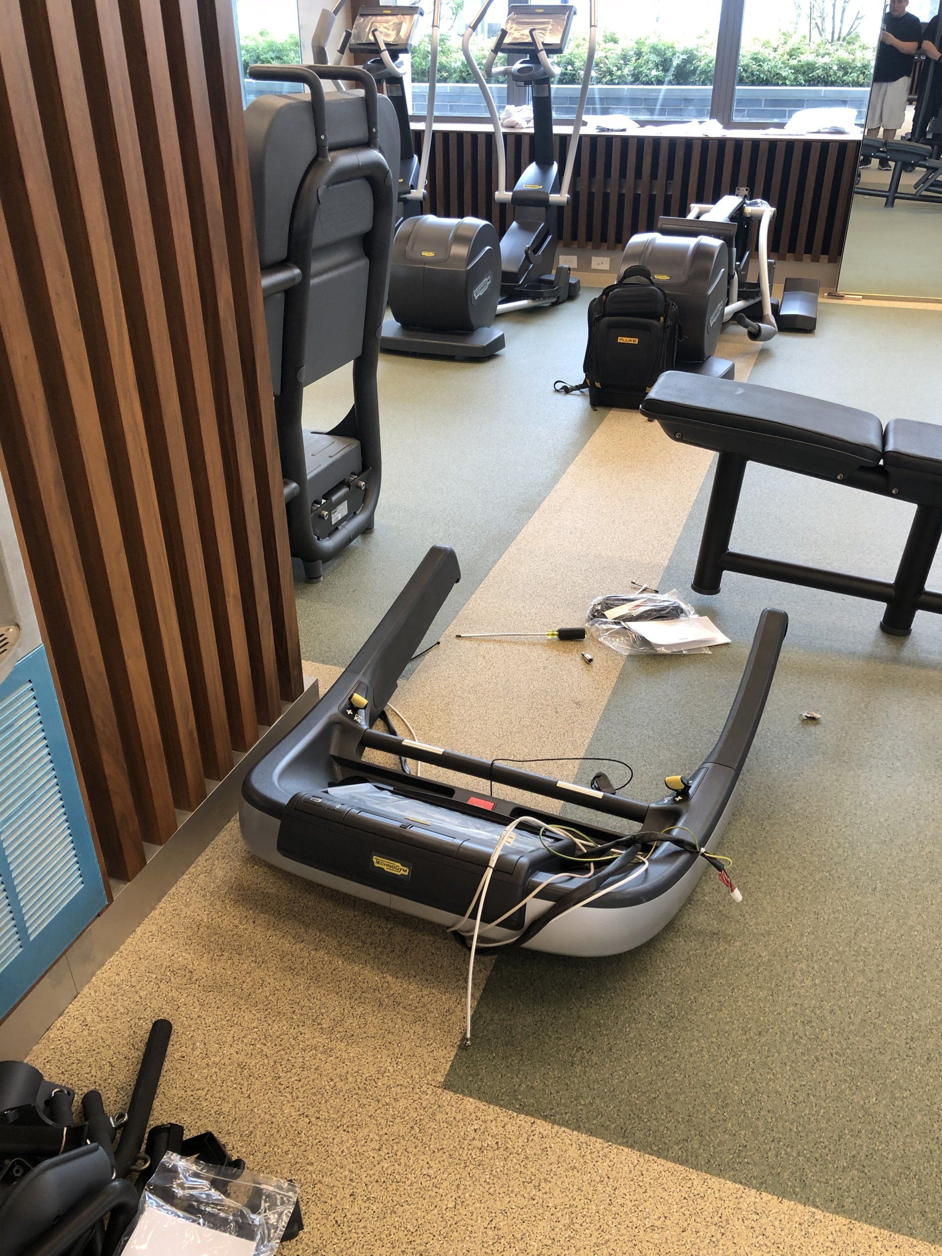 Gym equipment installation in progress at Iron State with cardio and strength machines.