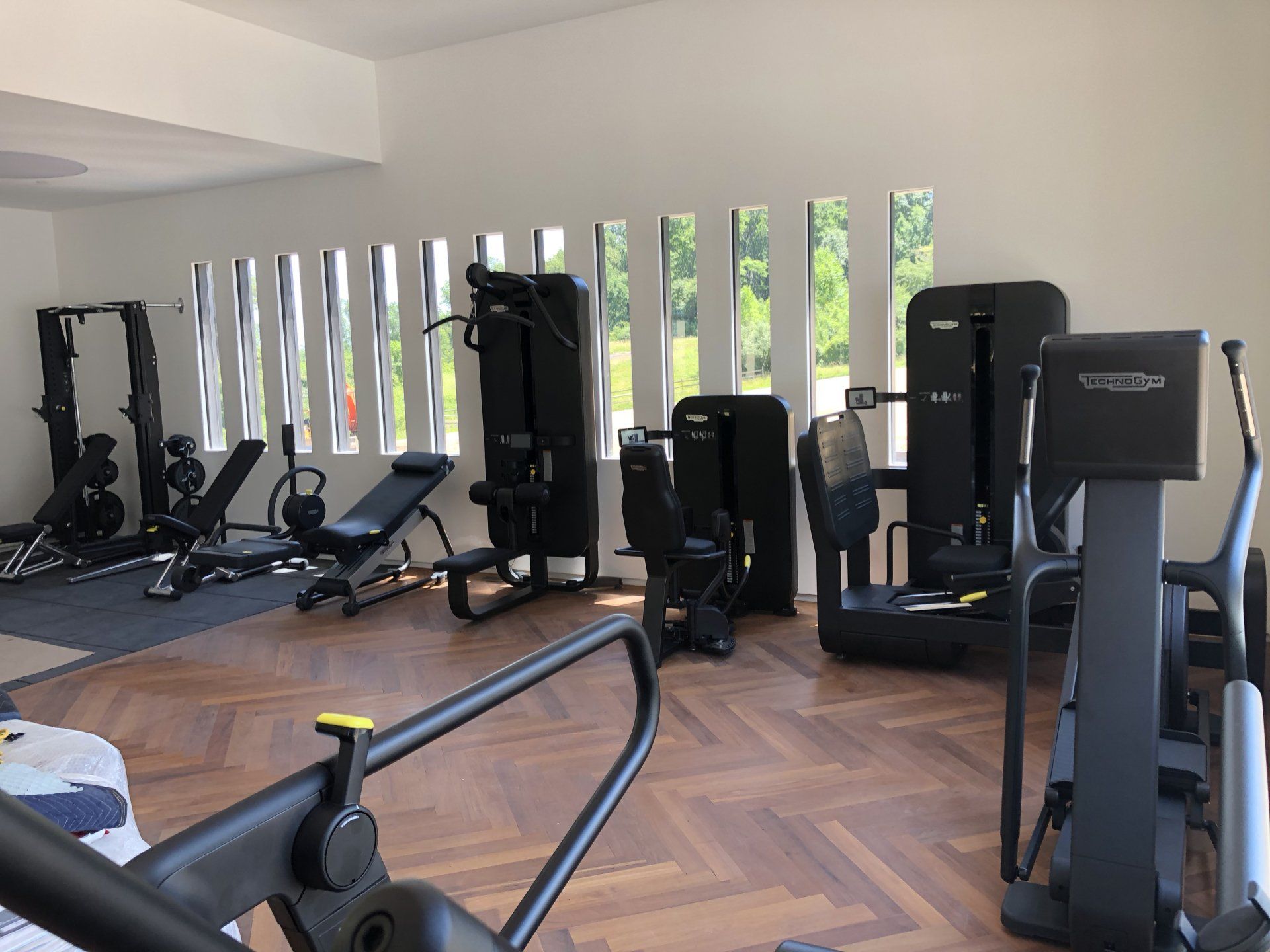 Modern fitness room with weight machines and natural light through vertical windows