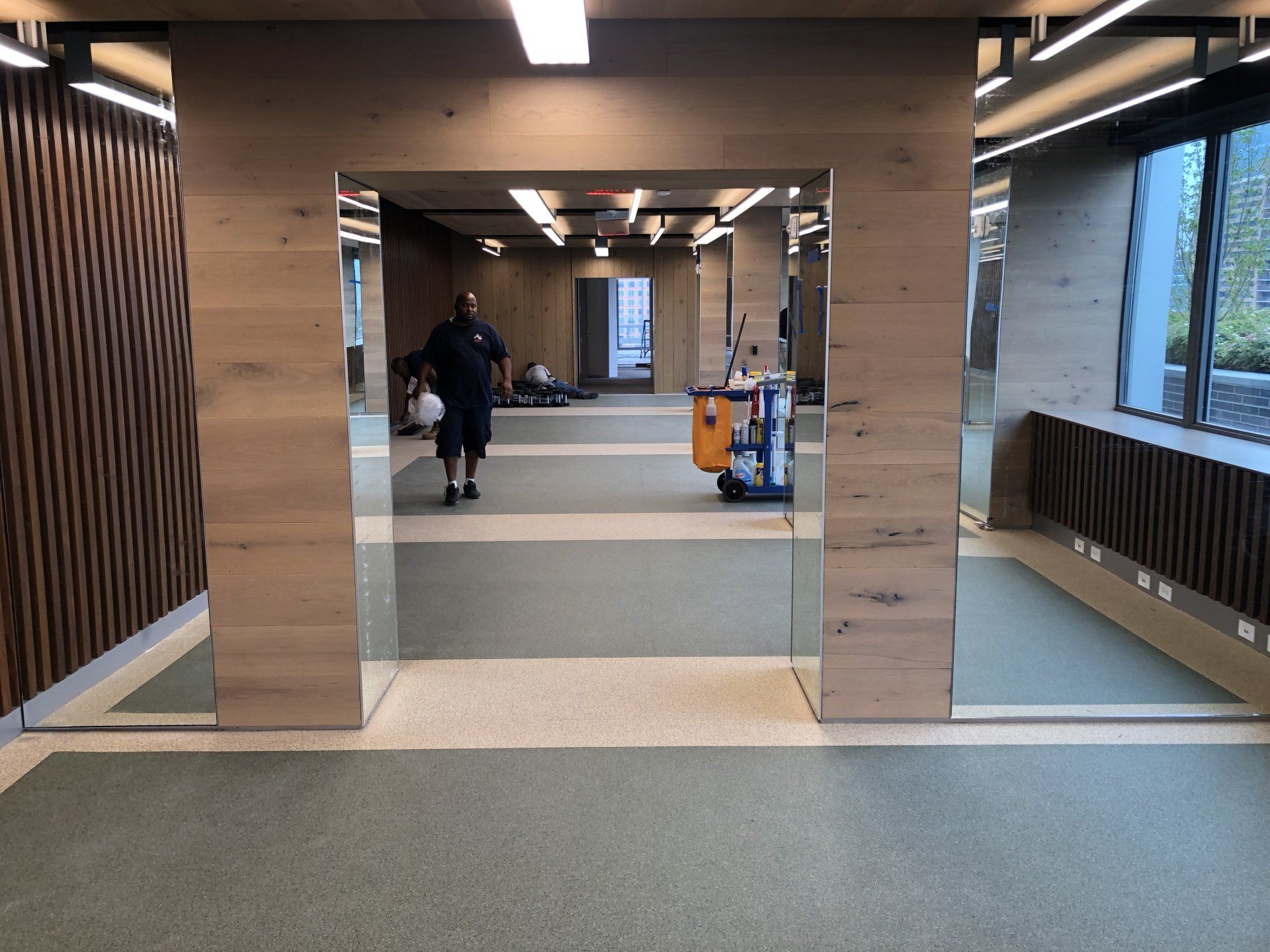 Spacious Iron State fitness room with wood accents, mirrors, and open exercise areas.