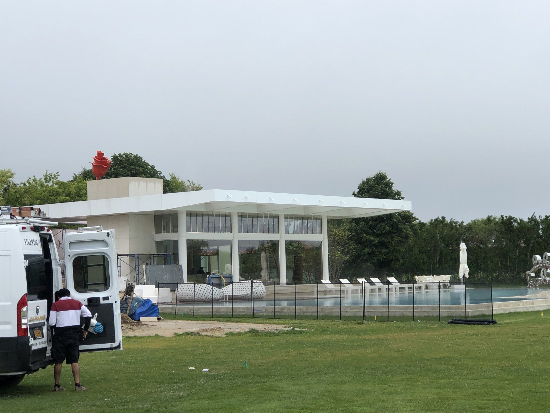 White modern residential build with poolside view in Bridgehampton