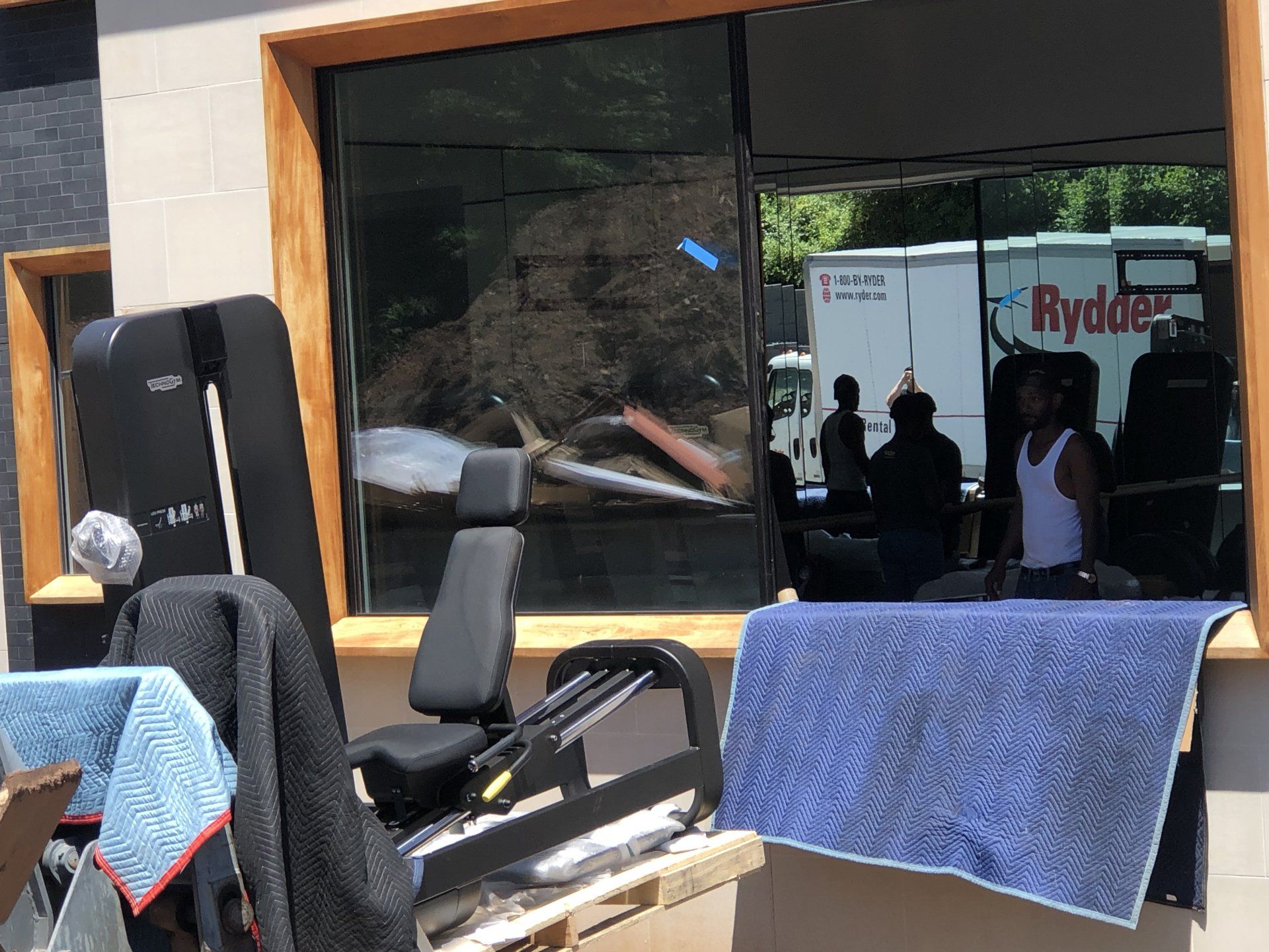 Residential build in Bernardsville with new gym machines staged near large glass windows.