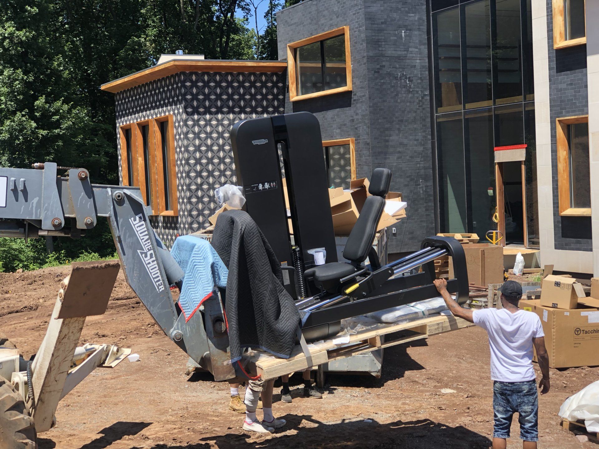 Workers moving fitness equipment outside Bernardsville residential build under construction.
