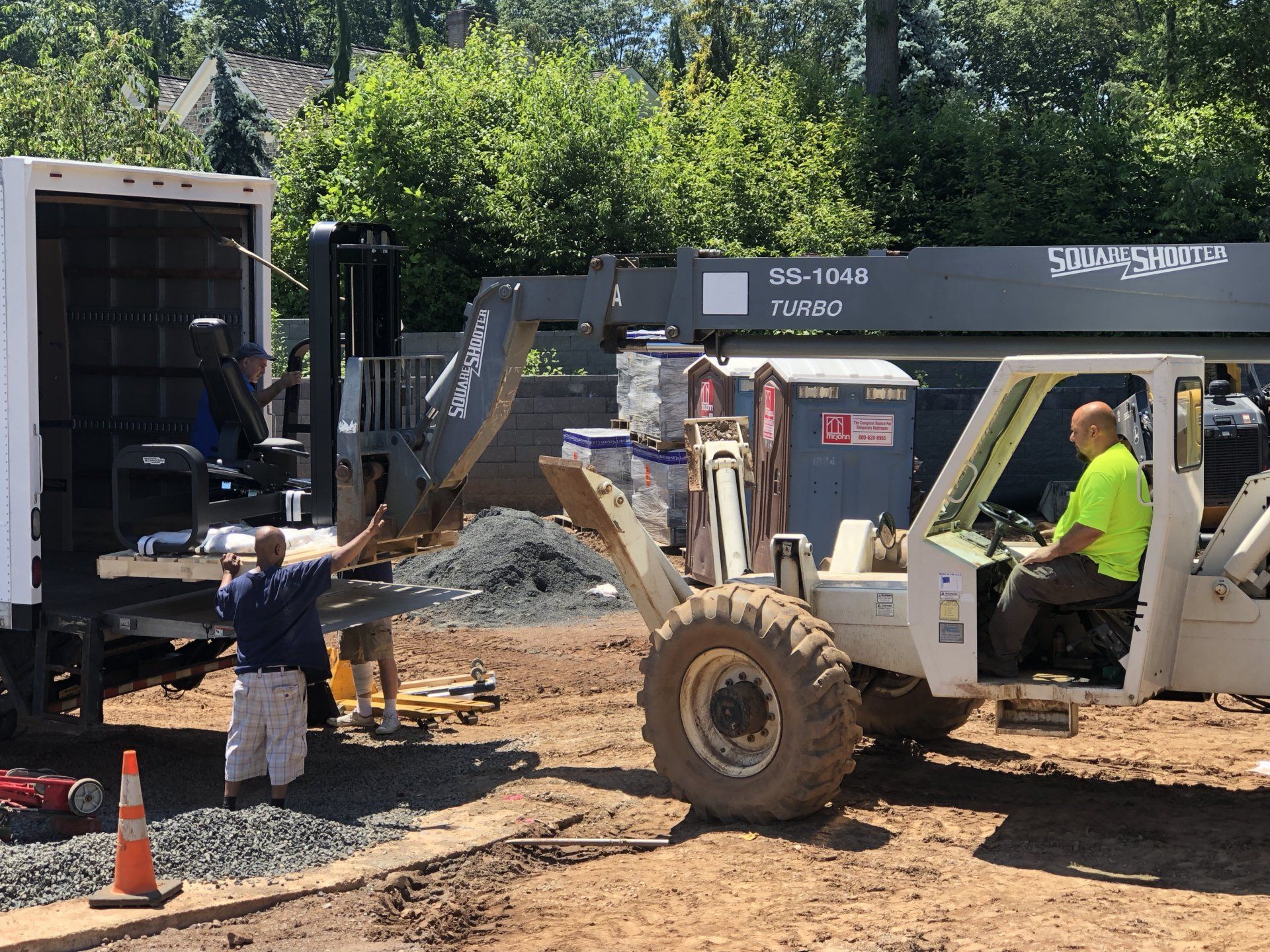 Workers using heavy machinery during Bernardsville residential construction site progress.