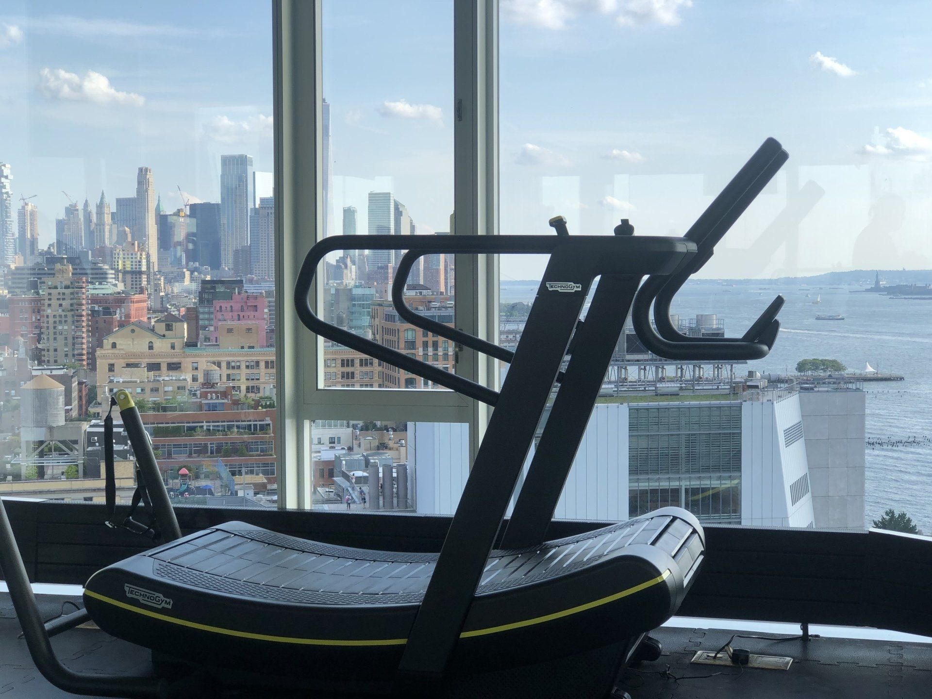 Side view of treadmill positioned by panoramic windows overlooking Manhattan skyline at The Standard.