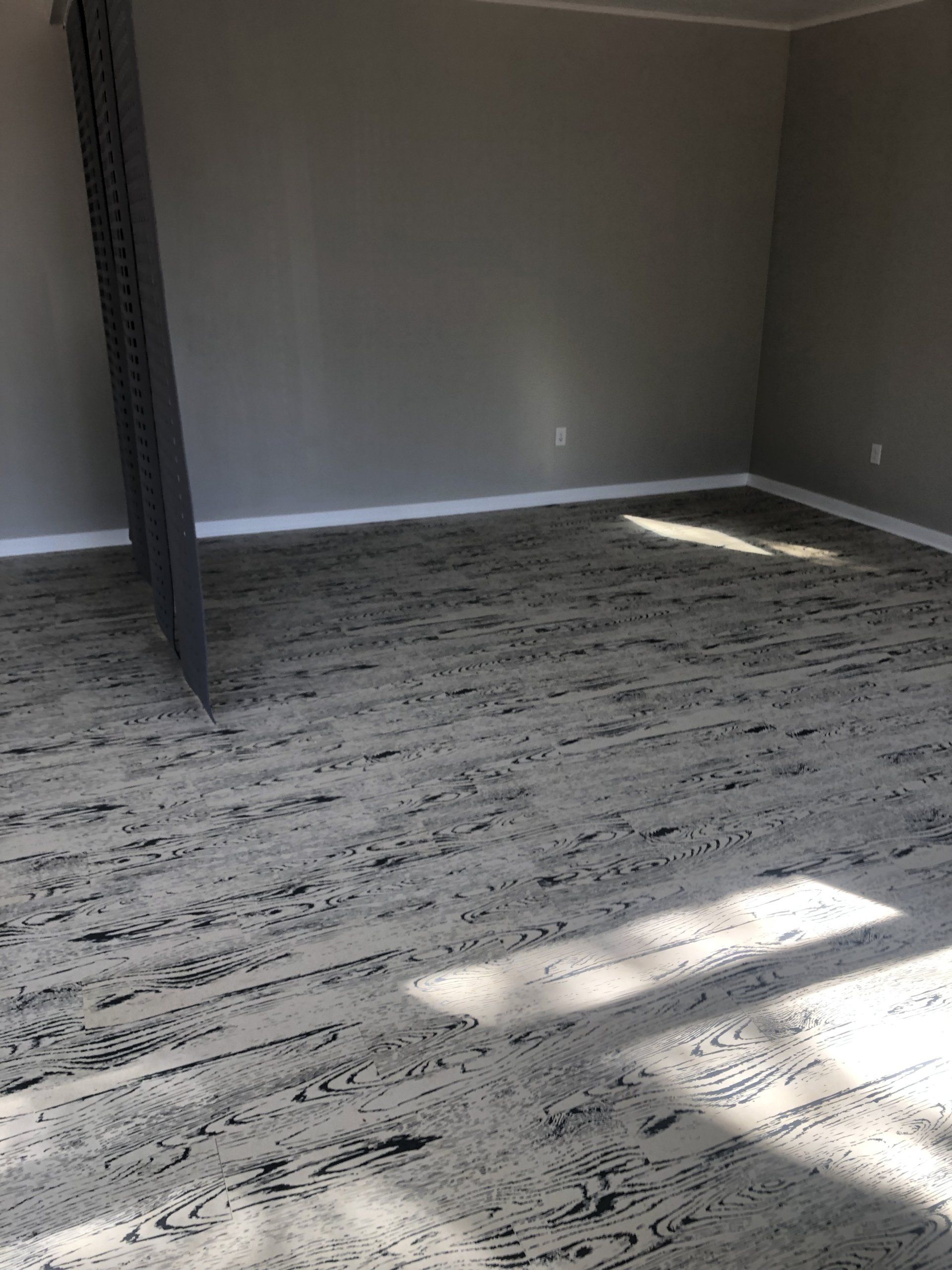 Empty workout studio with new wood-grain flooring at Daily Fitness.