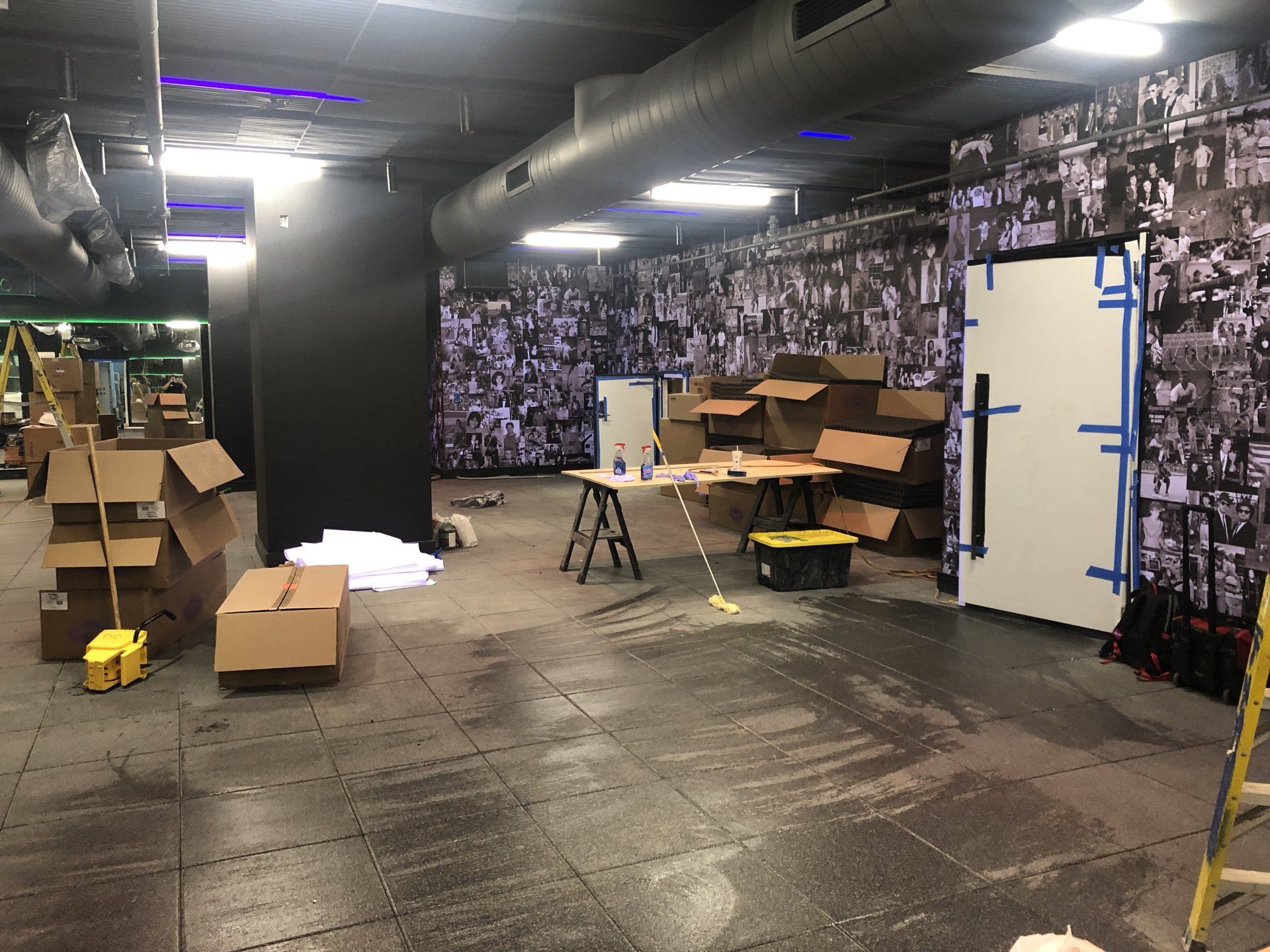 Fitness studio under construction with boxes and tools on the floor.