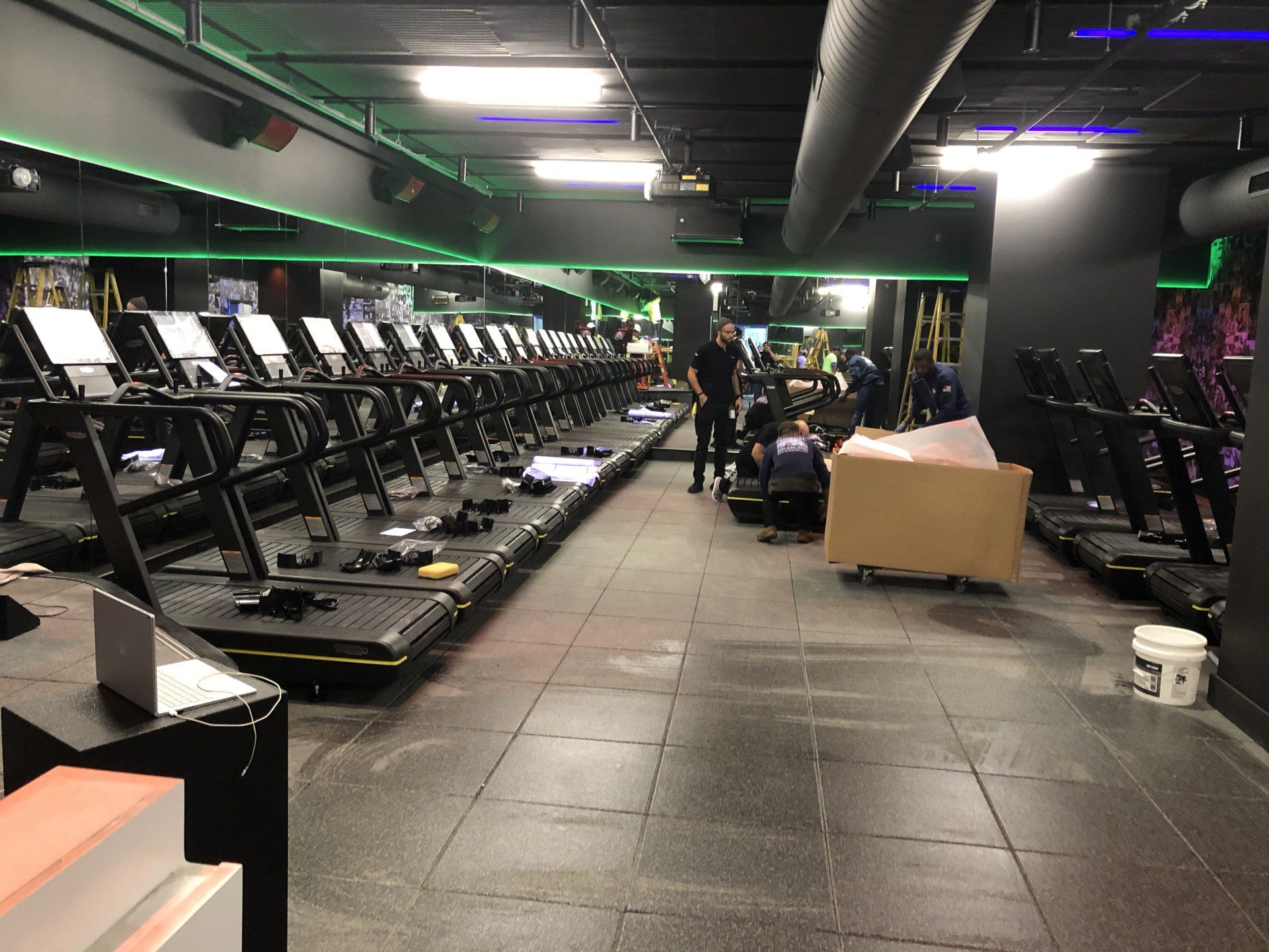Row of treadmills inside Rumble Fitness studio during installation.
