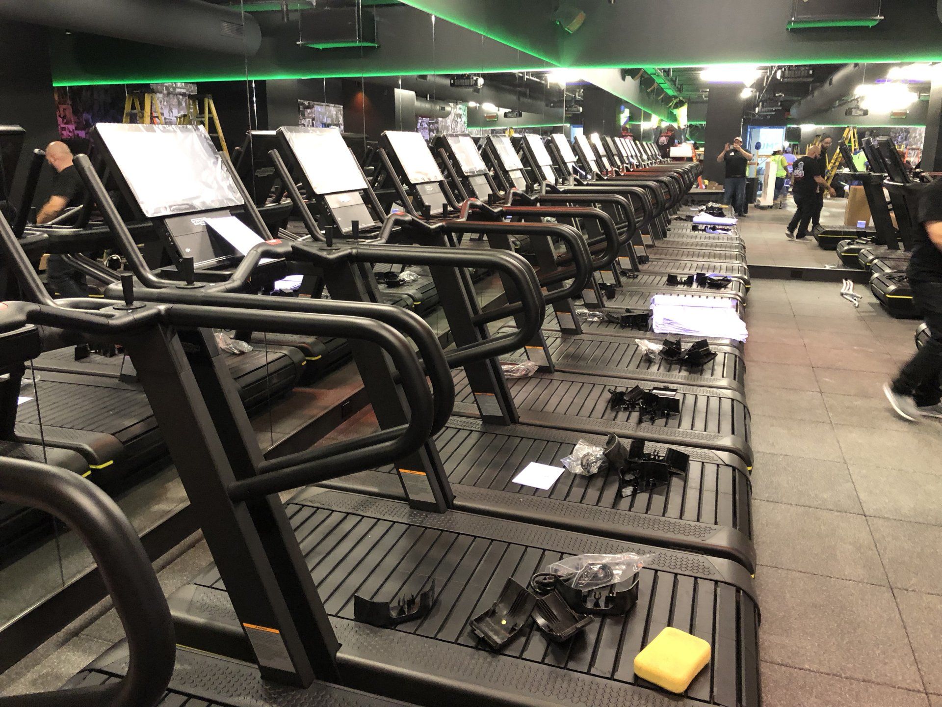 Row of treadmills being assembled inside Rumble Fitness gym.