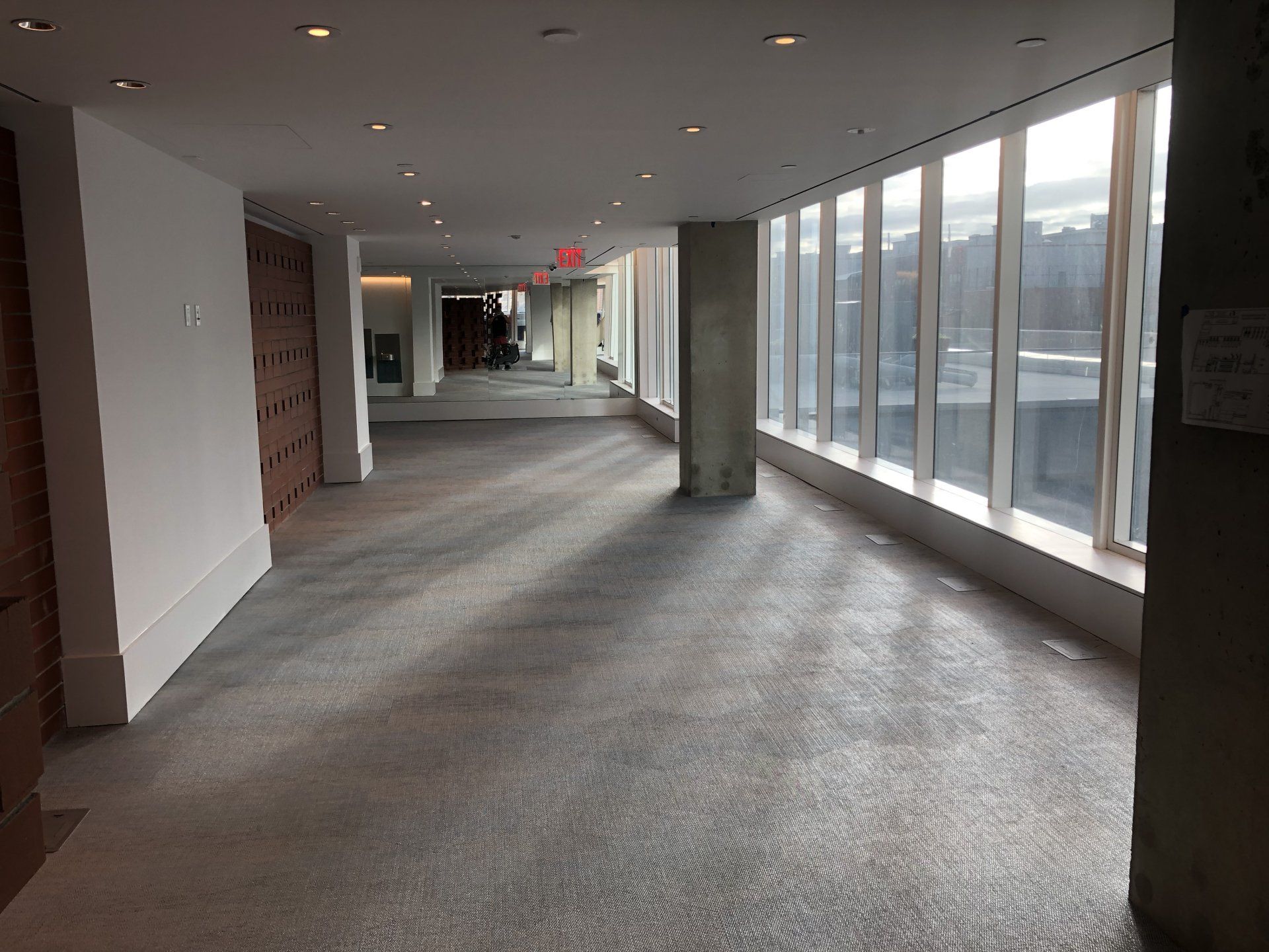 Spacious hallway with floor-to-ceiling windows inside luxury apartment building