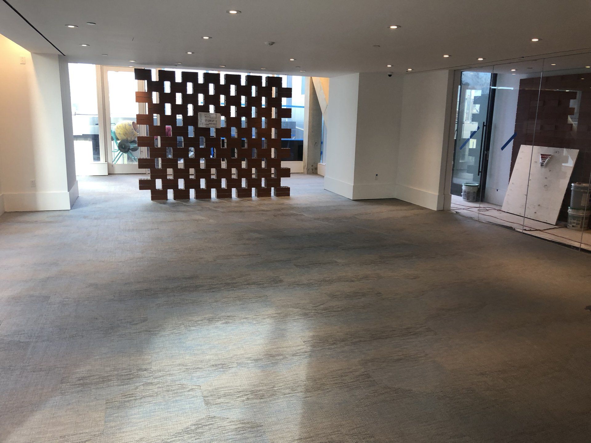 Open fitness and lounge area with decorative wood divider and bright windows