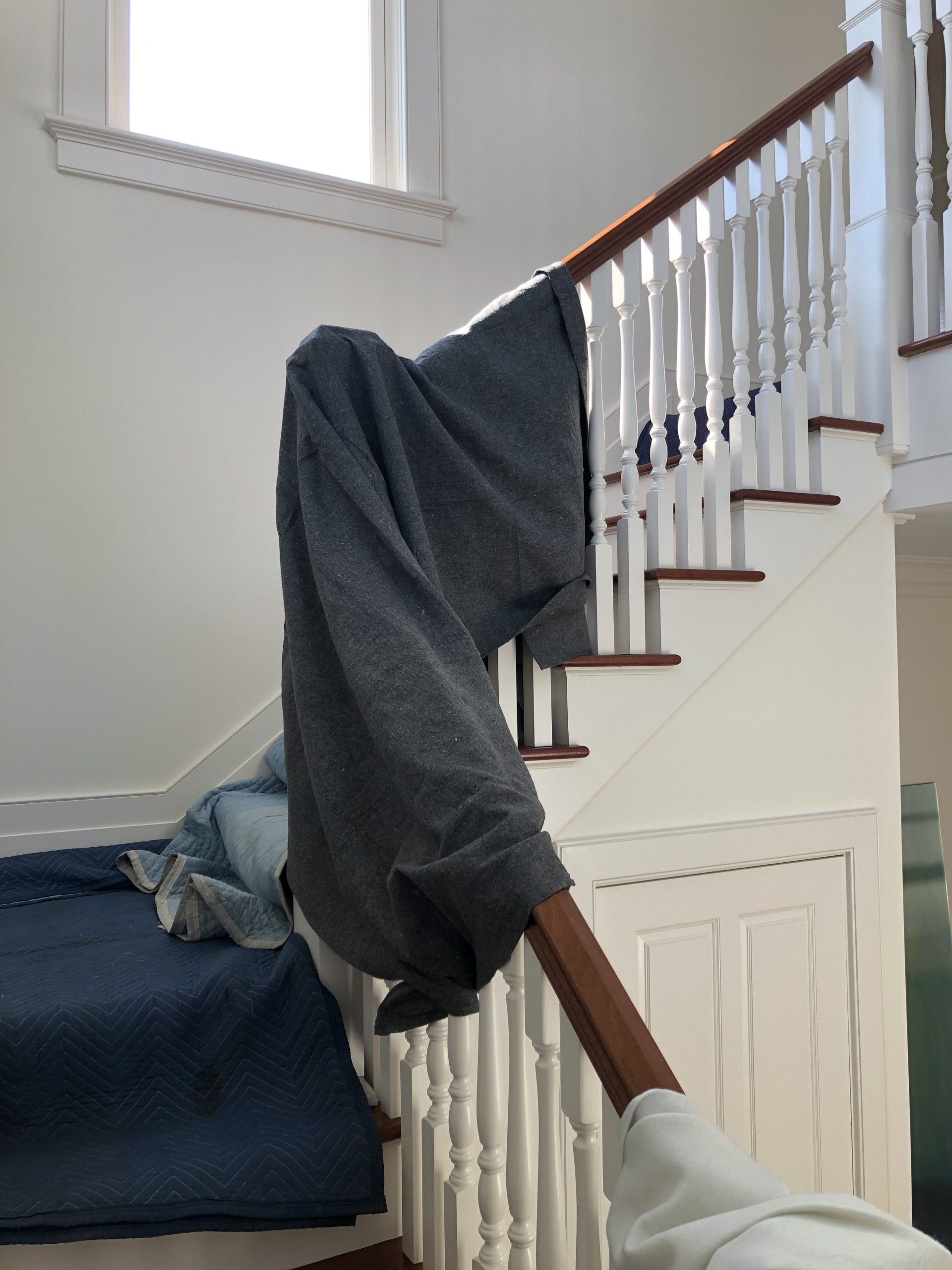 Interior stairway area with workers assembling fitness equipment.