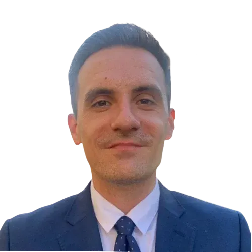 A man in a suit and tie is smiling for the camera