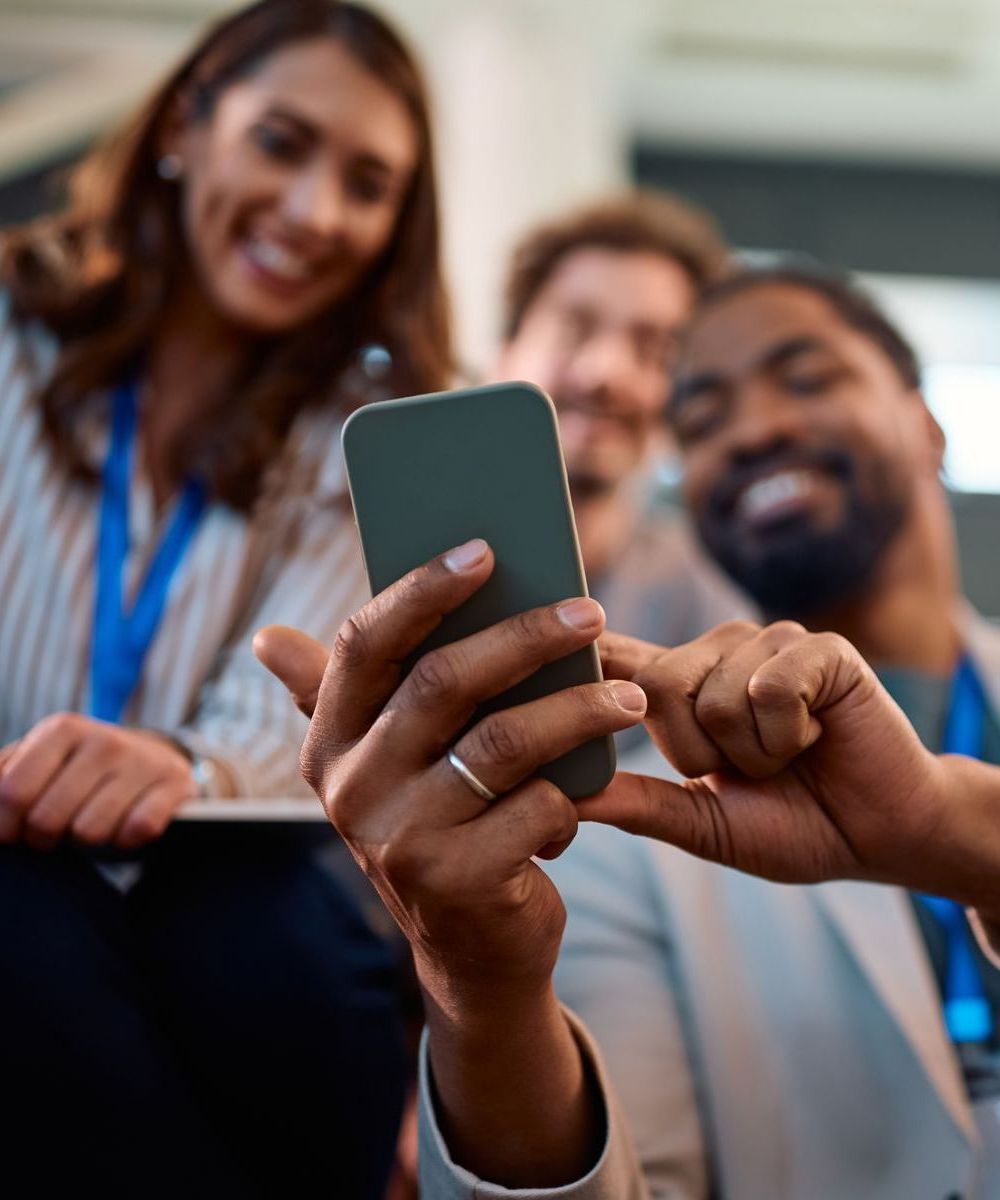 A group of people are looking at a cell phone