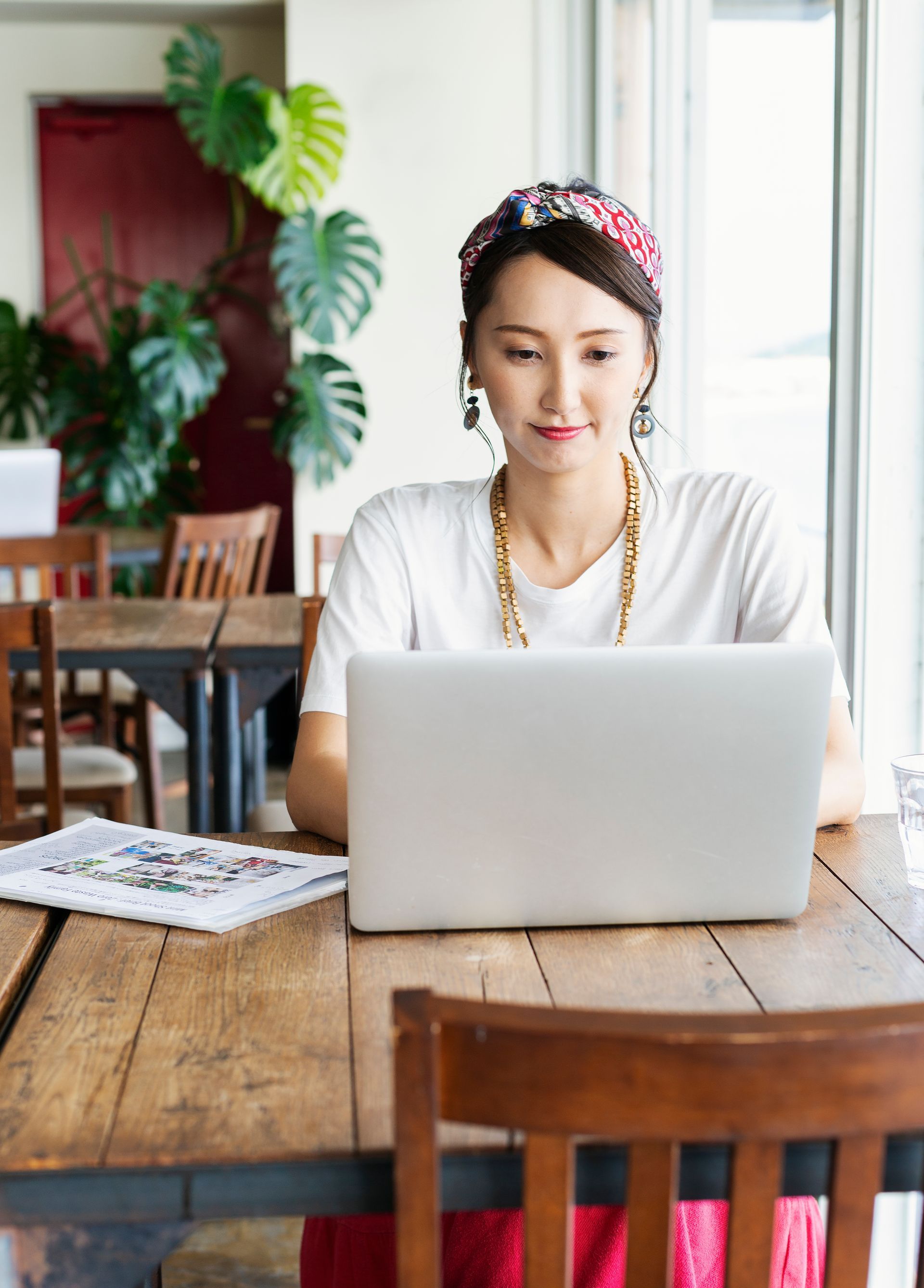 A woman is sitting at a table using a laptop computer.