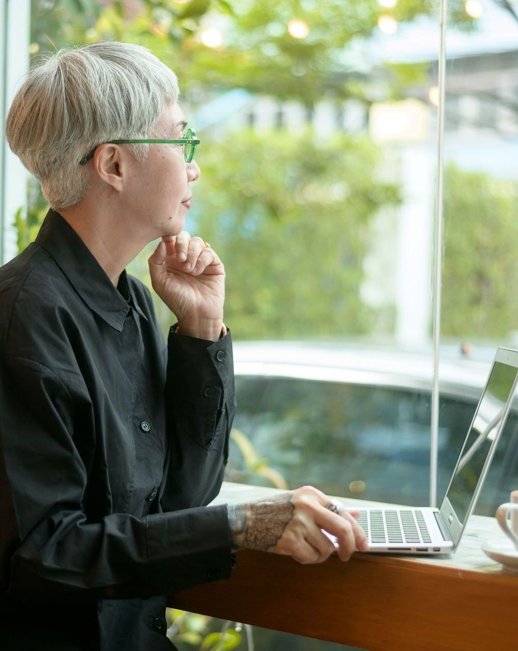 A woman is sitting at a table using a laptop computer.