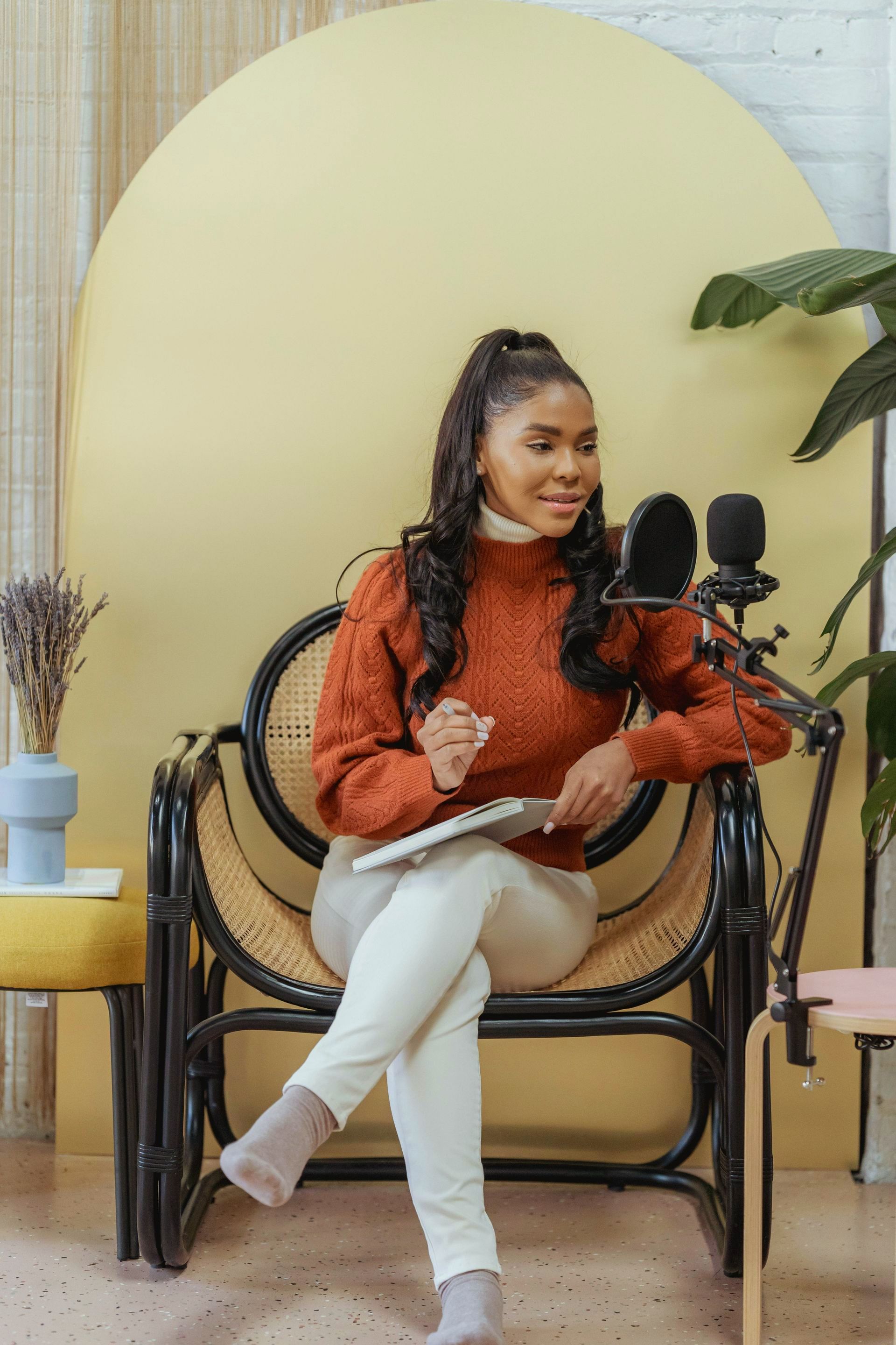 A woman is sitting in a chair with a microphone and a tablet.