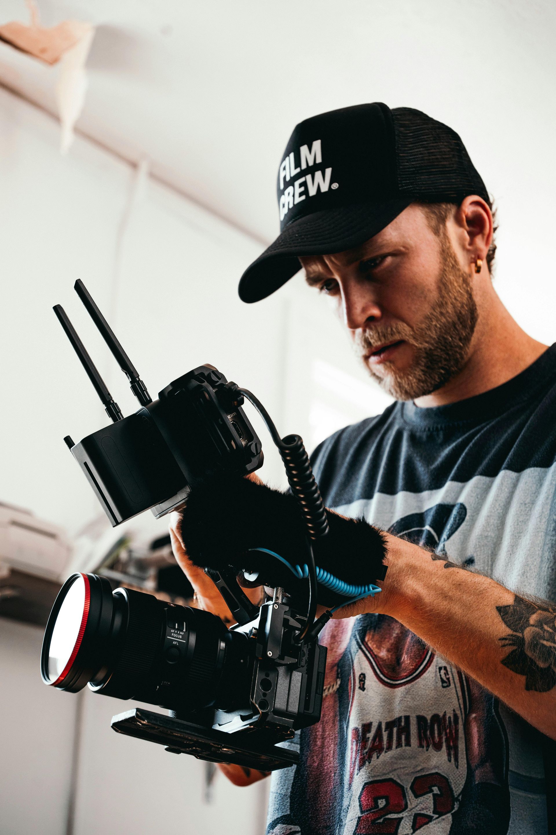 A man in a black hat is holding a camera.