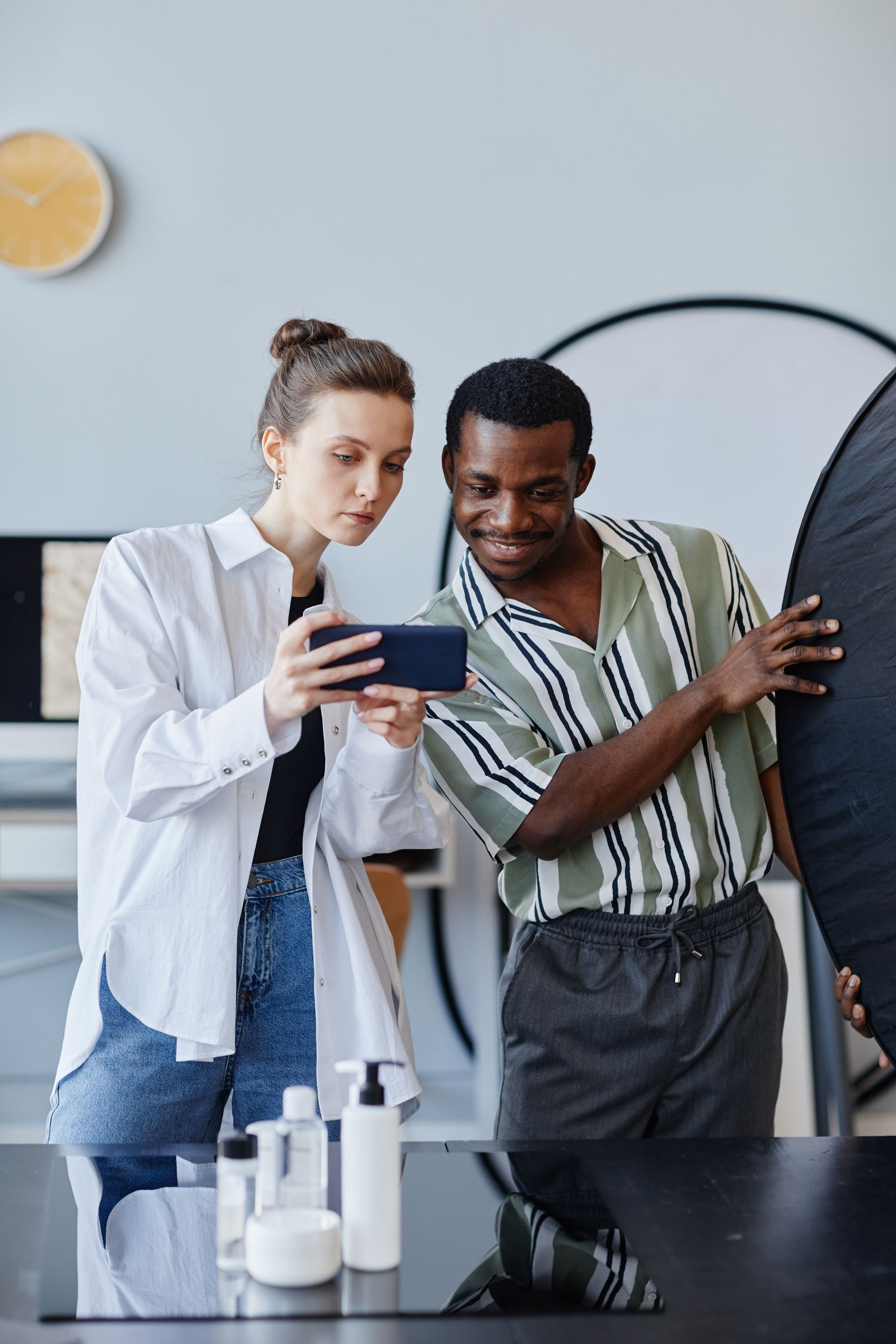 A man and a woman are looking at a cell phone.
