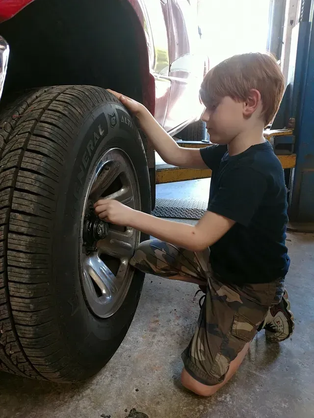Child Helping Inspect Tire Inside Auto Repair Shop | Rock's Tire & Auto