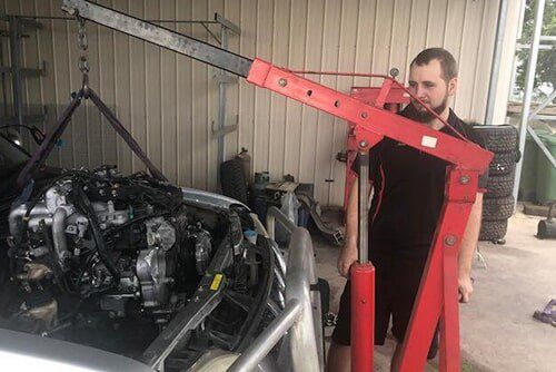 Car Engine Being Lifted into Car — Automotive Repairs  in Blackwater, QLD