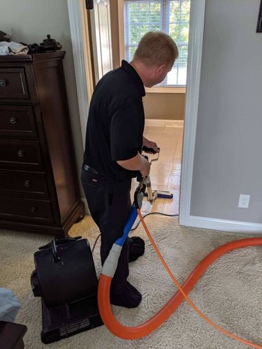 Man cleaning carpet with a machine. Man cleaning carpet with a machine.
