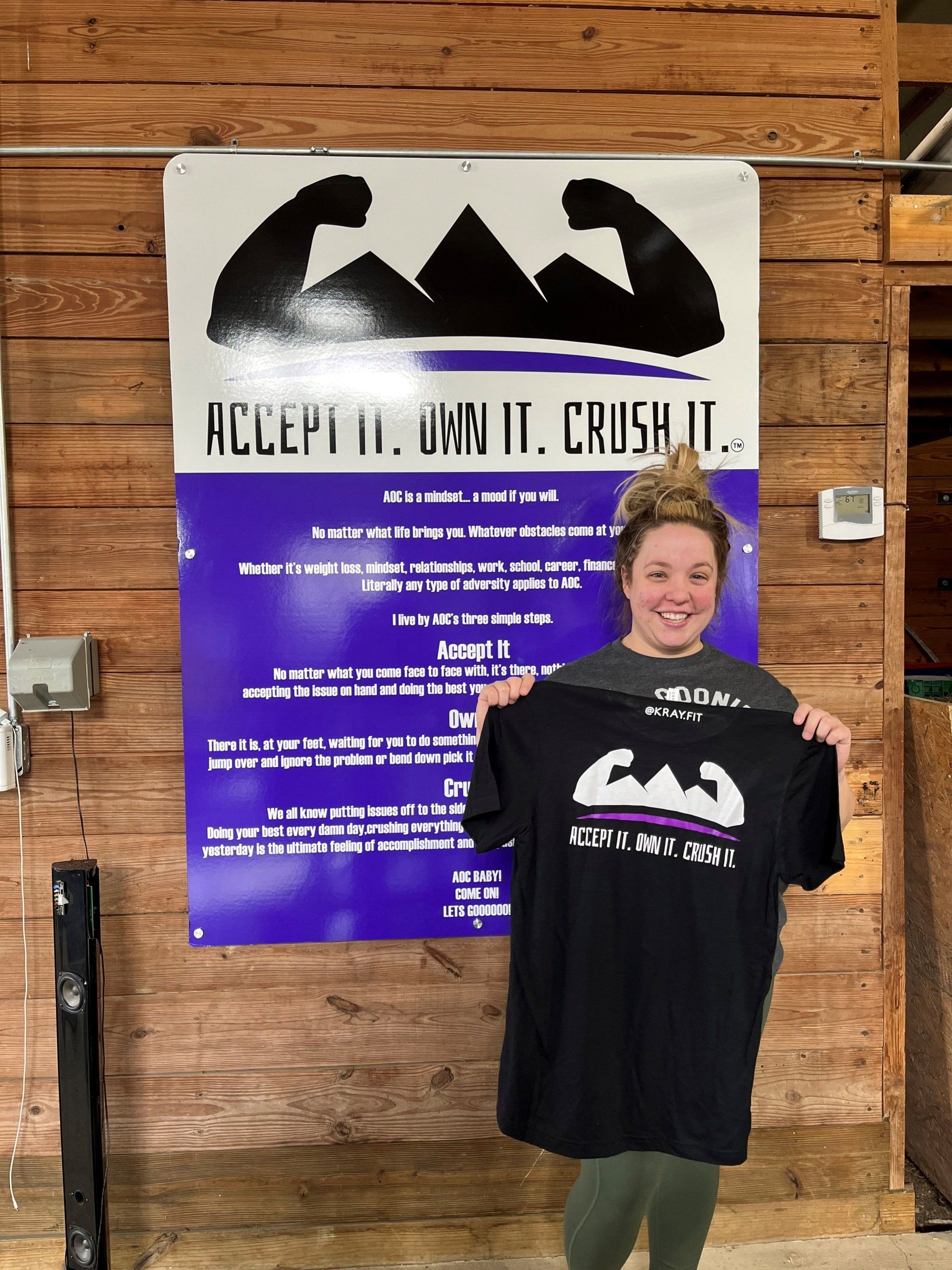 Woman Holding A Shirt — Monee, IL — K-Ray Fitness At AOC Gym