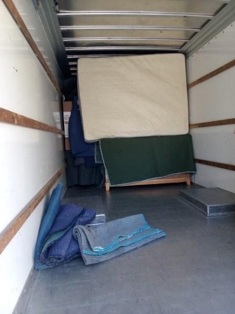 A mattress is sitting in the back of a moving truck