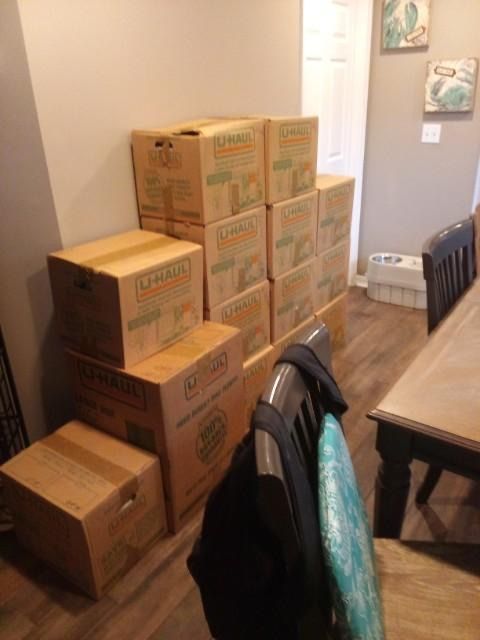 A bunch of cardboard boxes are stacked on top of each other in a room.