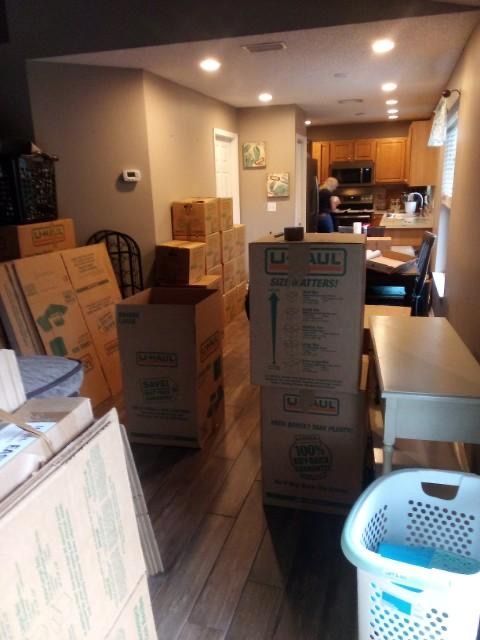 A room filled with cardboard boxes and a laundry basket