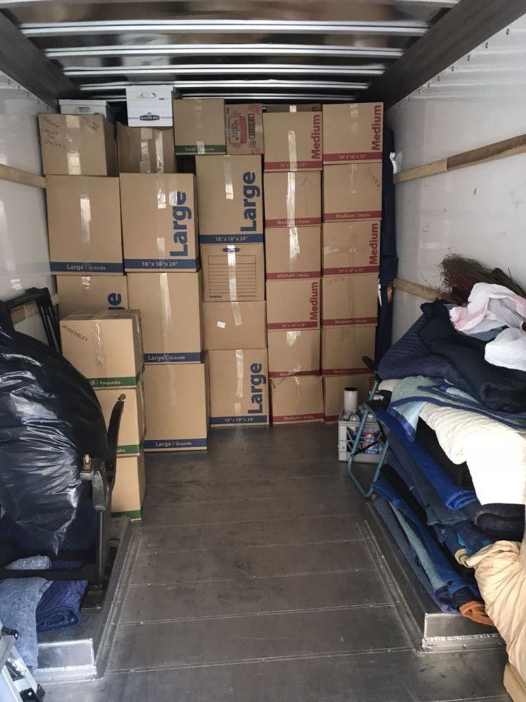 The inside of a large moving truck filled with boxes