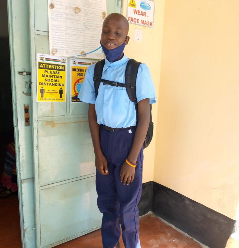 Ein Mann mit einer Maske steht vor einer Tür mit der Aufschrift „Gesichtsmaske tragen“