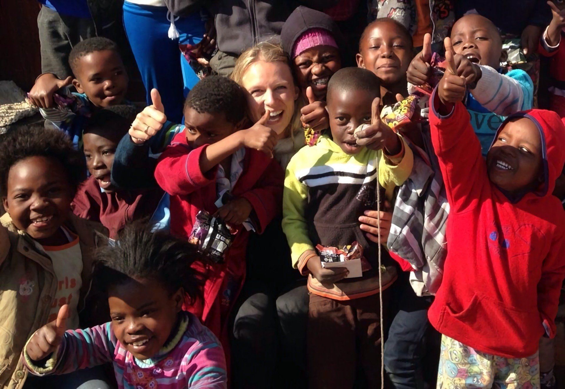 Eine Gruppe von Kindern posiert für ein Foto und gibt einen Daumen hoch