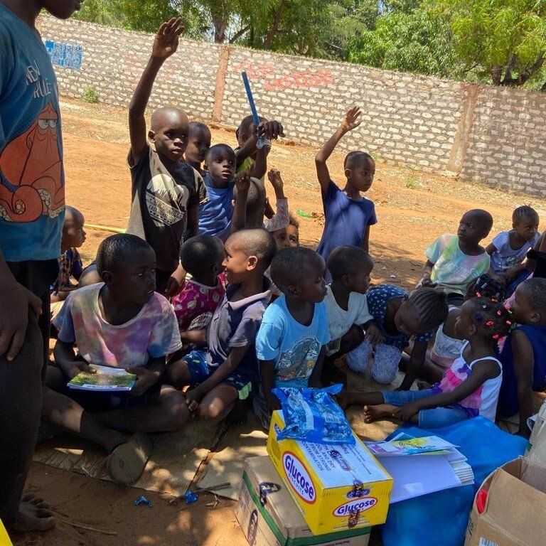 Eine Gruppe von Kindern sitzt um eine Schachtel Quaker